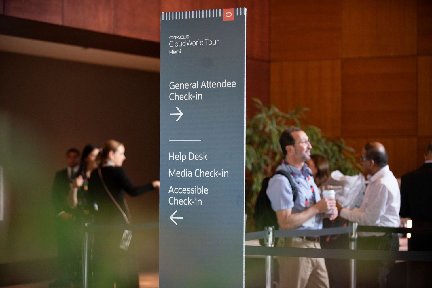 Oracle CloudWorld Tour event sign directing attendees to General Attendee Check-In, Help Desk, and Media Check-In areas.