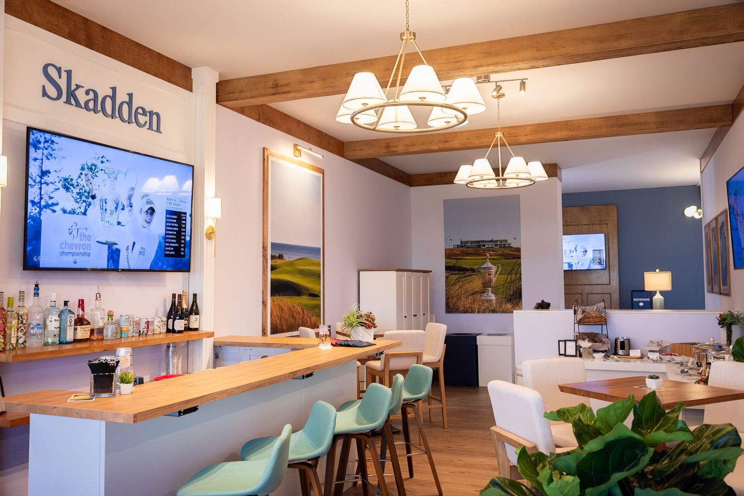Corporate event photography of a company suite at the U.S. Open Golf Championship in the Hamptons, NY featuring exposed beams and modern bar