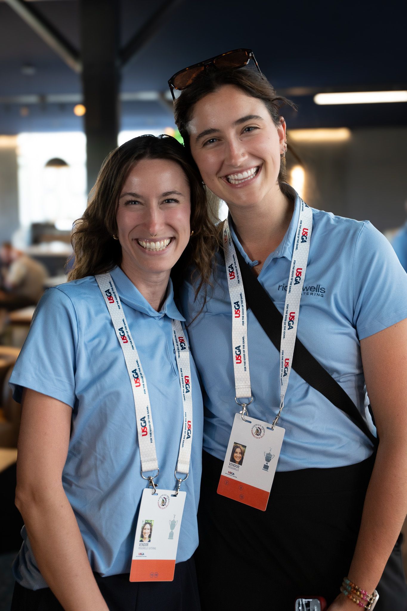 Corporate event photography of two female staff smiling inside the 1895 Club at the U.S. Open Golf Championship in the Hamptons, New York.