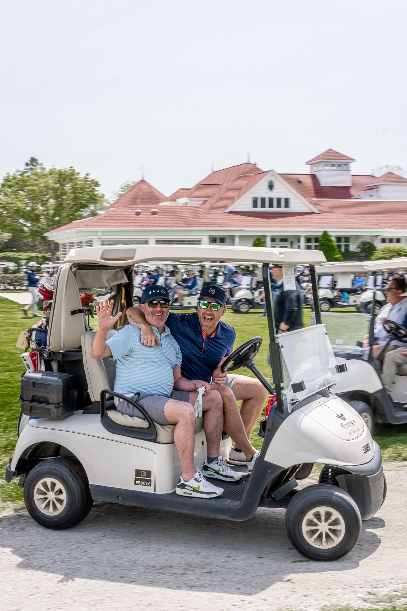 Event photography of two men on a golf cart at a charity tournament at Wentworth by the Sea Country Club in Portsmouth, New Hampshire.