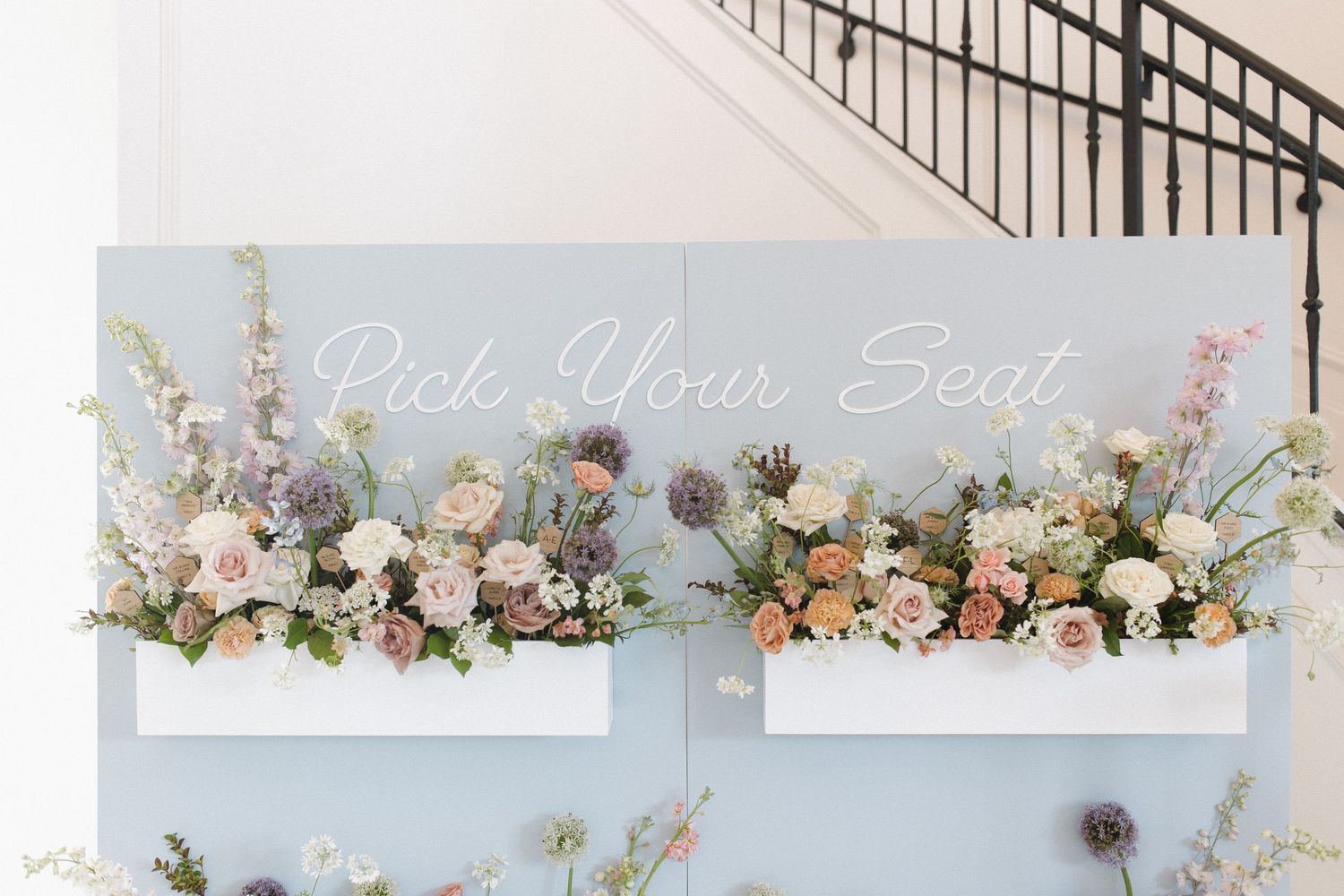 Wall with flowers doubling as escort cards for guests to find their seats at a luxury estate wedding reception in Newport, Rhode Island