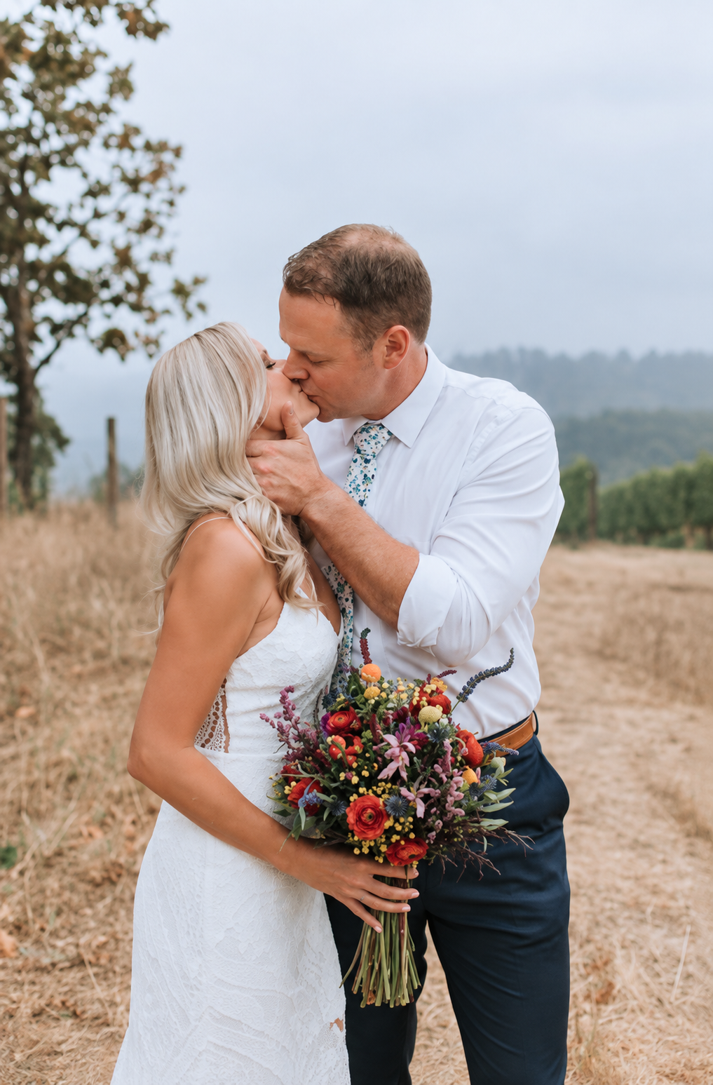 Groom holds his new wife's face and kisses her deeply at their romantic outdoor Fall wedding in North Shore, Massachusetts