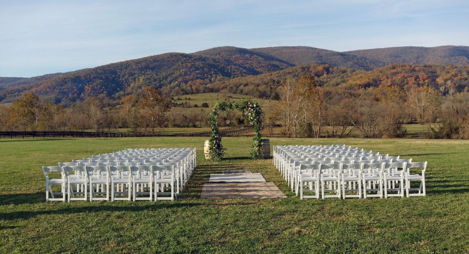 Wedding ceremony chairs in front of a floral archway and wine barrels on a Fall day for a wedding in Charlottesville, Virginia