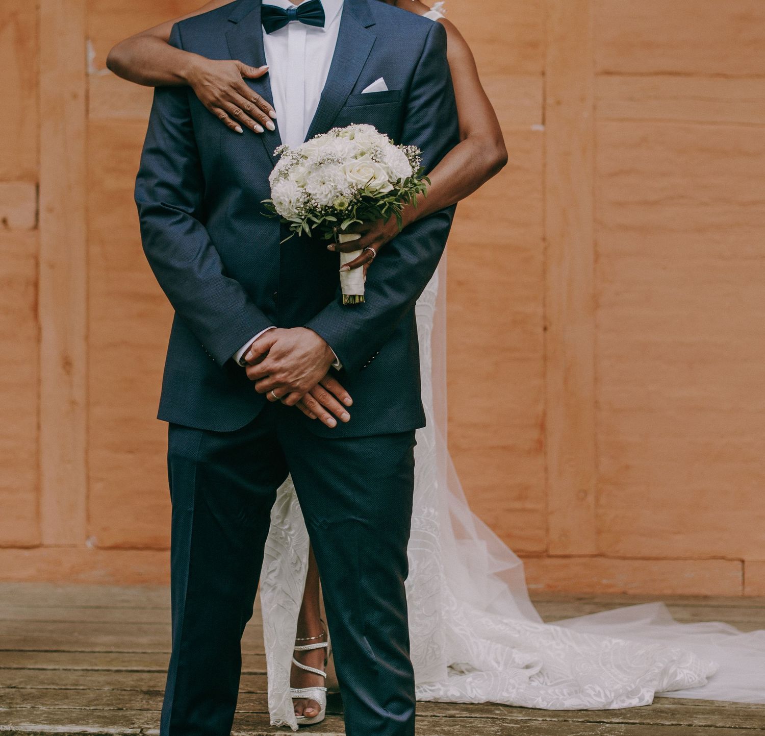 Chic black couple embraces for first look images in front of wood doors prior to their luxury New England wedding in Newport, Rhode Island