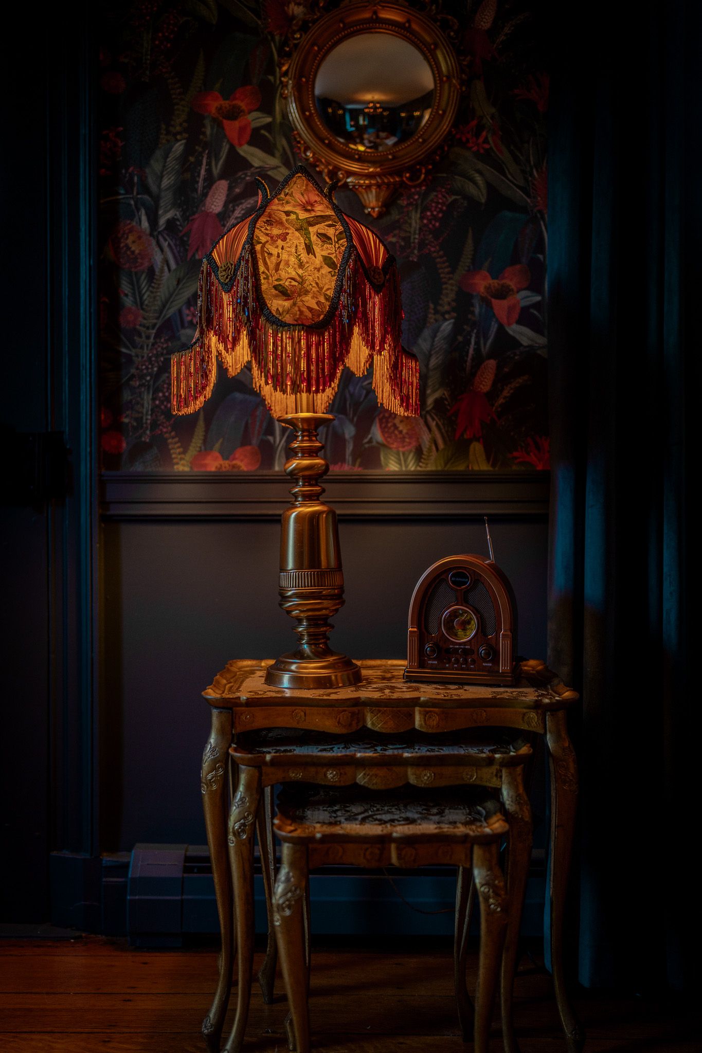 A dimly lit room featuring antique tables, an antique radio, and fringed lamp before a wedding reception at Willowood Washington in Maryland