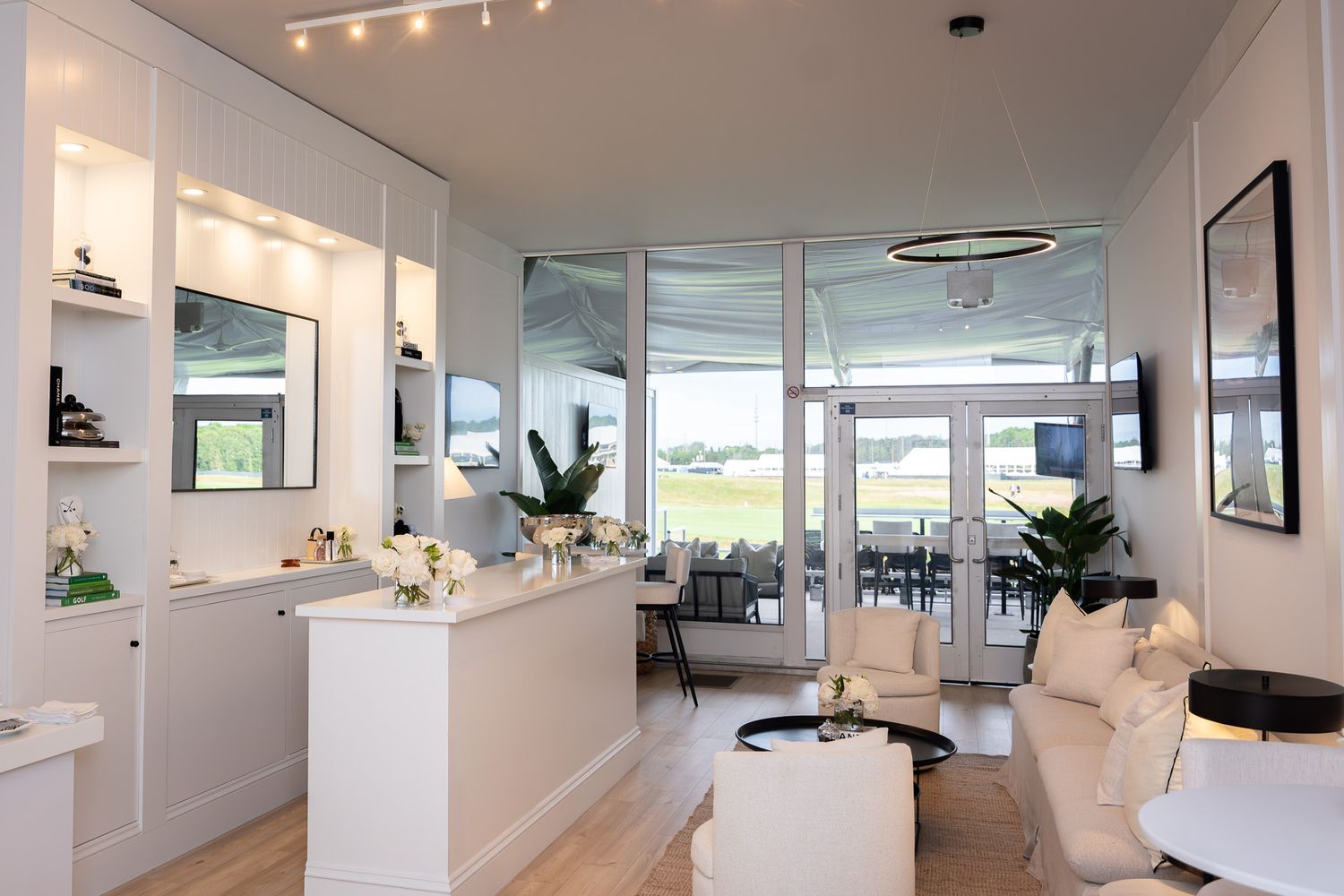 Corporate event photography of a company suite at the U.S. Open Golf Championship in the Hamptons, NY featuring a white Chanel branded bar