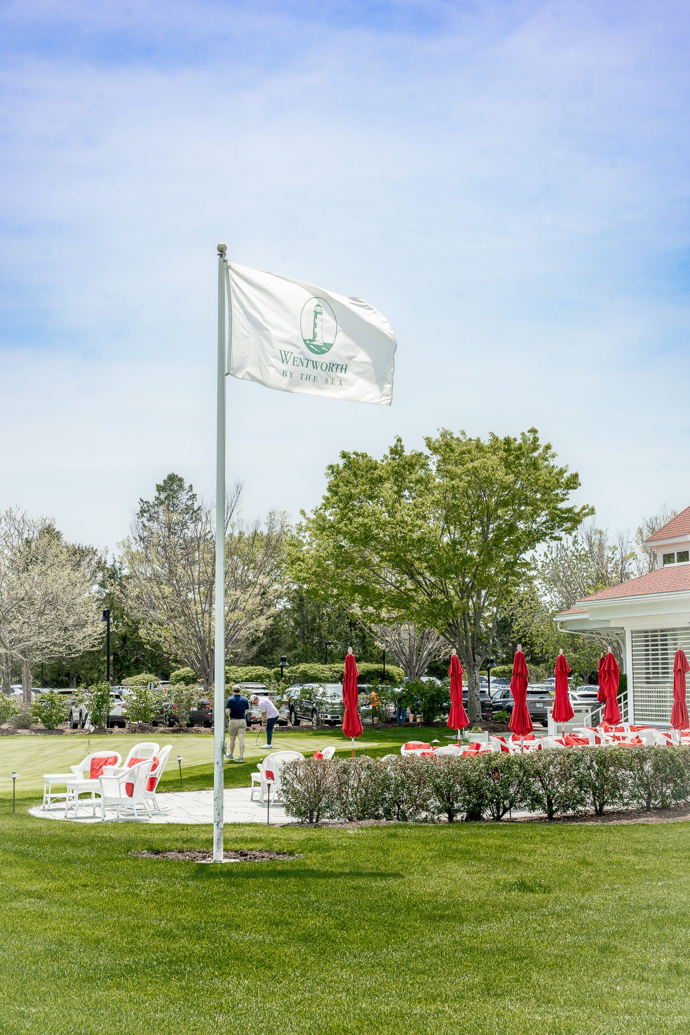 Event photography of a flag waving in the wind on a warm Spring day at Wentworth by the Sea Country Club.