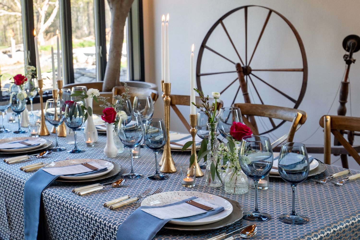A luxuriously set table and lit candles with a large antique wooden spindle in the background before a corporate event in Middleburg, VA