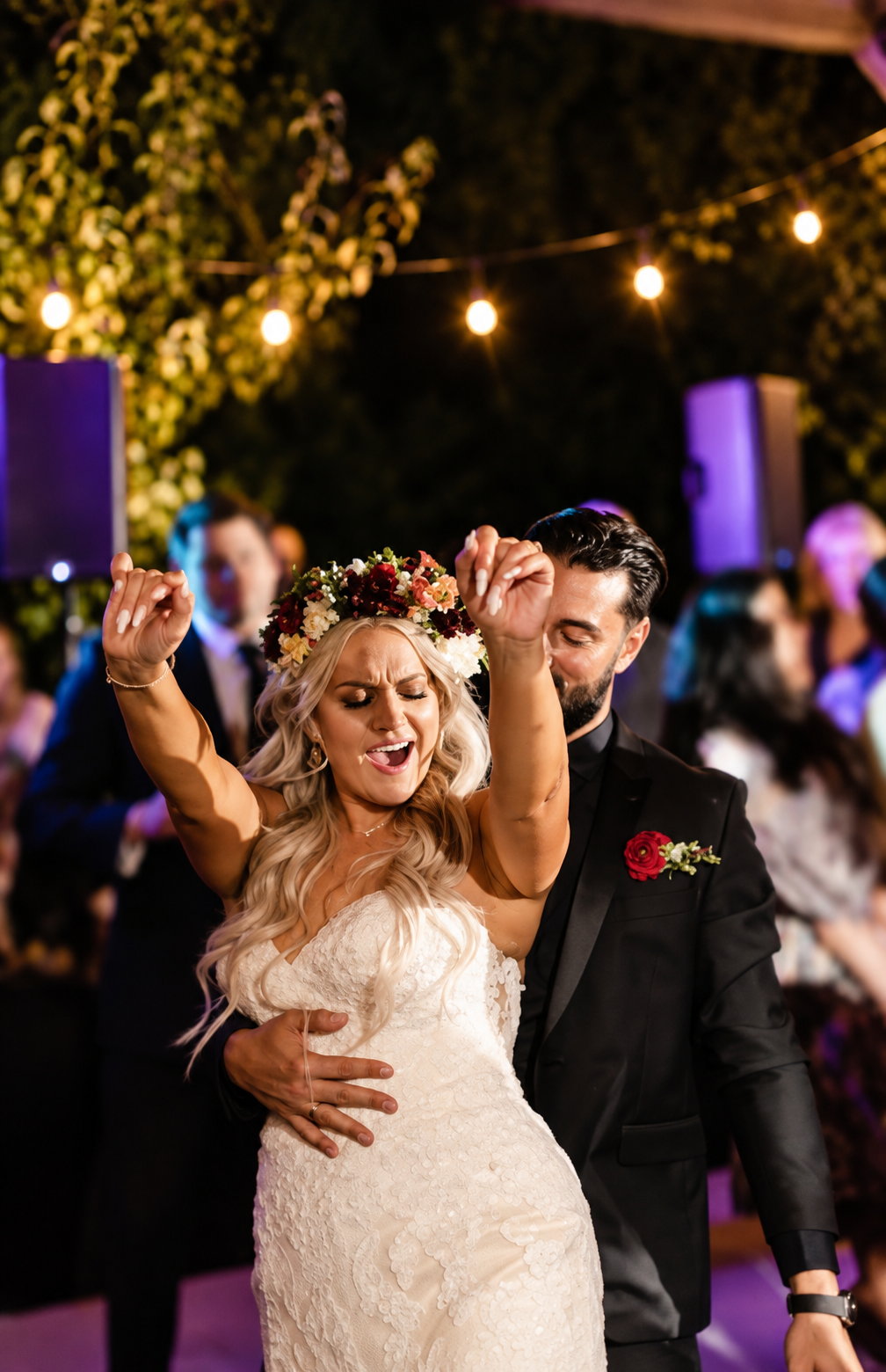 Bride and groom dancing and laughing loudly surrounded by family and friends at their joyful modern city wedding in Boston, Massachusetts
