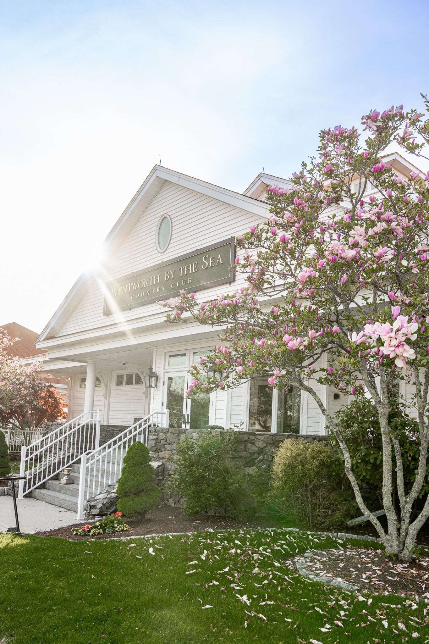 Wedding photography of Wentworth by the Sea Country Club featuring a classic coastal white shingled building with a red roof on a Spring day