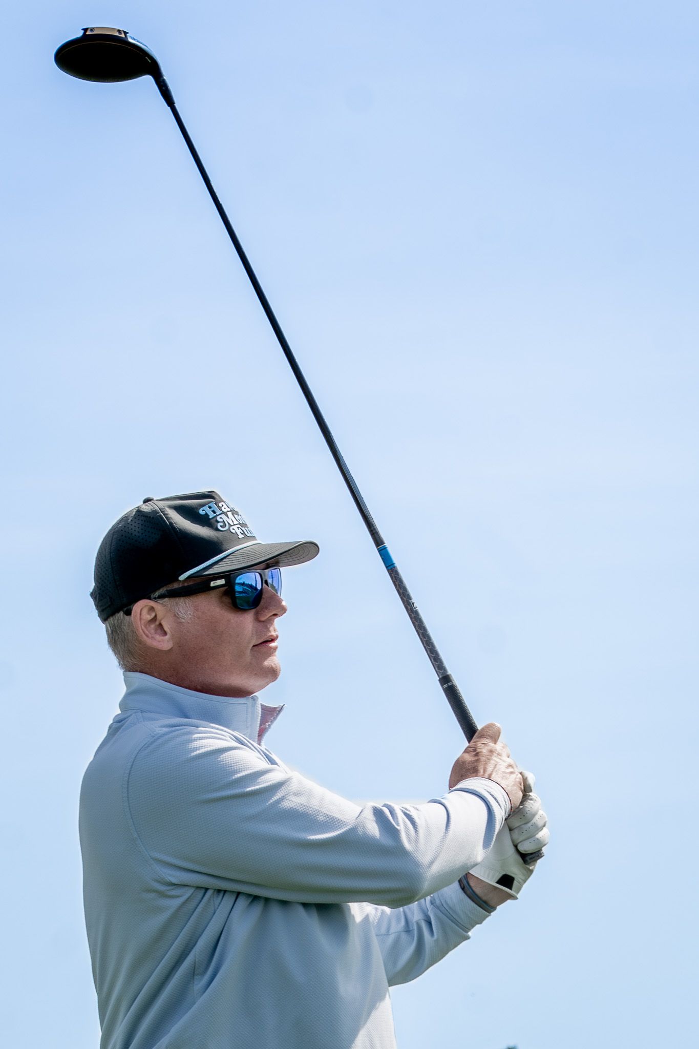 Event photography of a man swinging his golf club during a charity fundraiser golf tournament at Wentworth by the Sea Country Club.