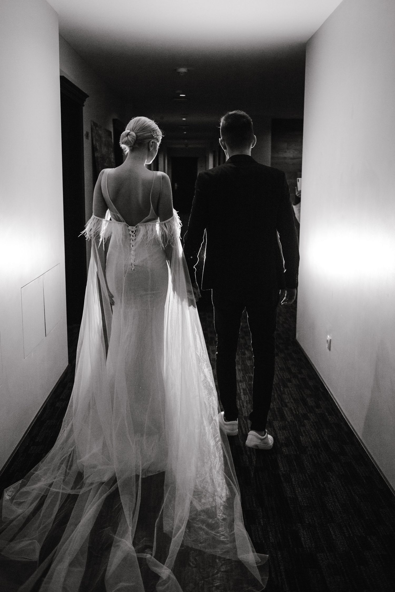 Bride and groom walking down hotel hallway holding hands after their wedding ceremony in Boston, Massachusetts