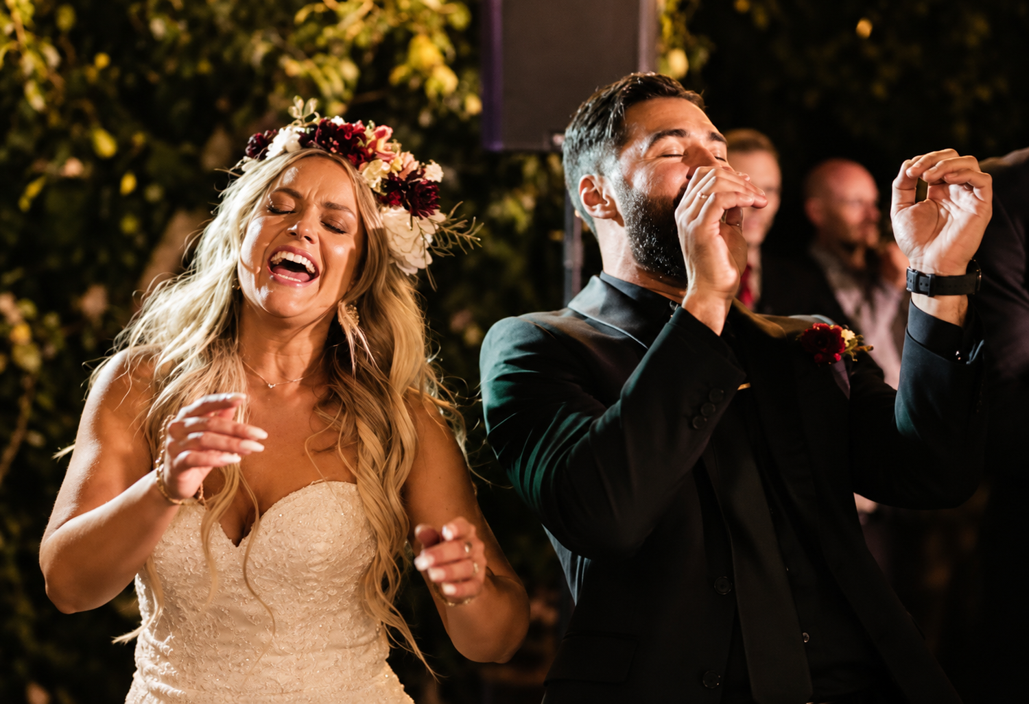 Bride and groom dance and sing loudly surrounded by friends and family at their joyful modern urban wedding in Boston, Massachusetts