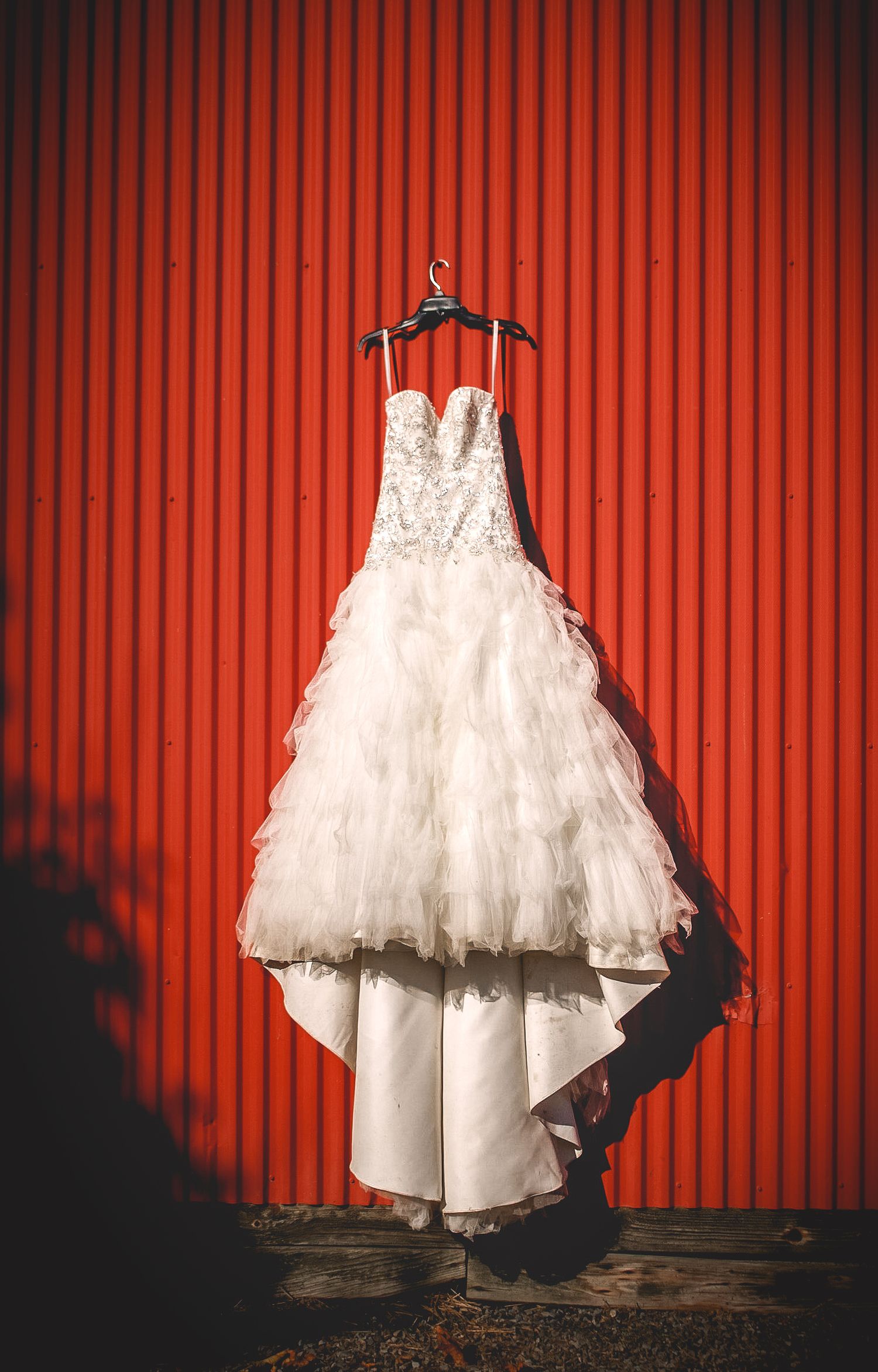 Cinematic image of a wedding dress against a boldly textured wall before an urban luxury wedding in Boston, Massachusetts