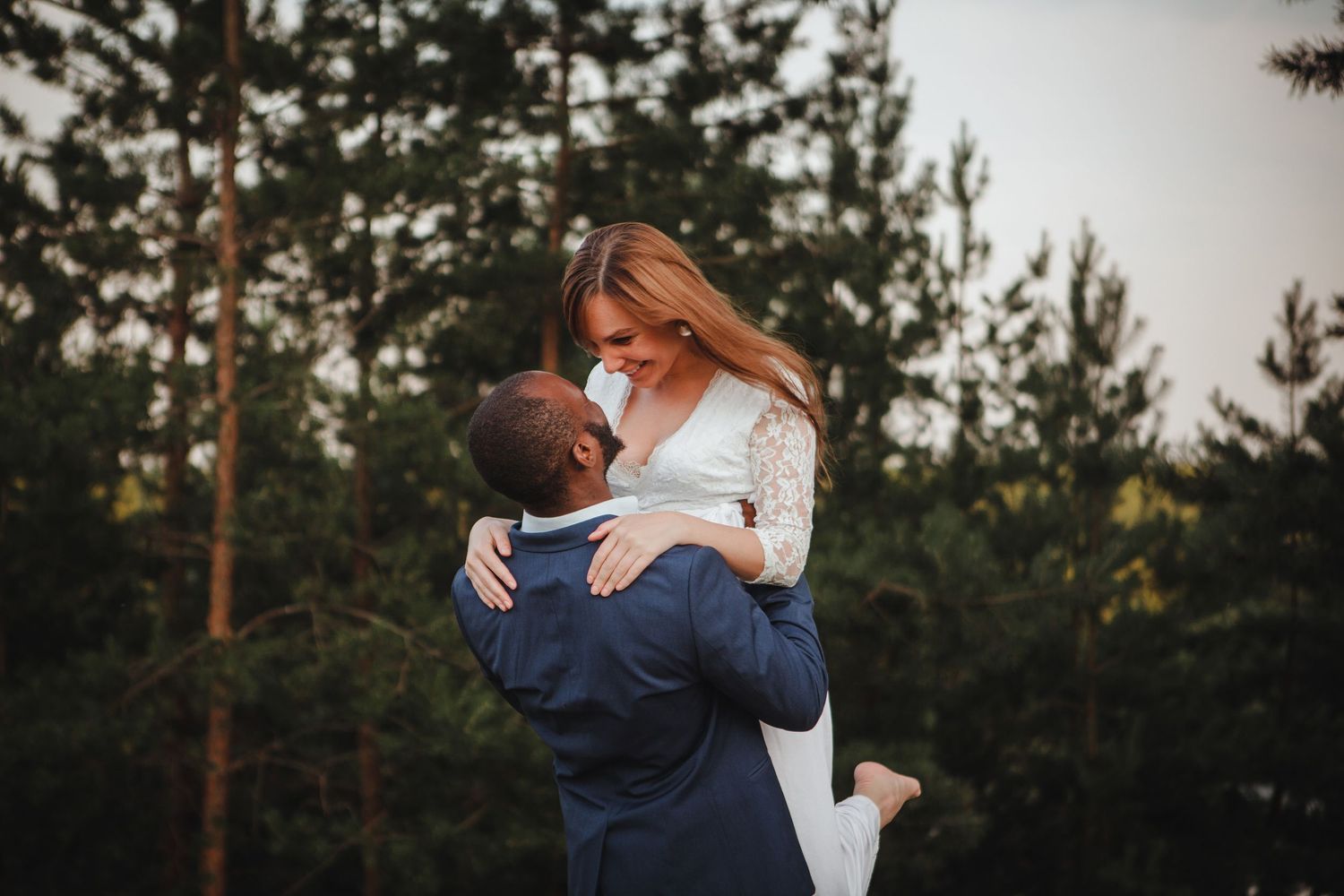 Groom lifting and twirling his bride during a joyful outdoor wedding portrait in Boston