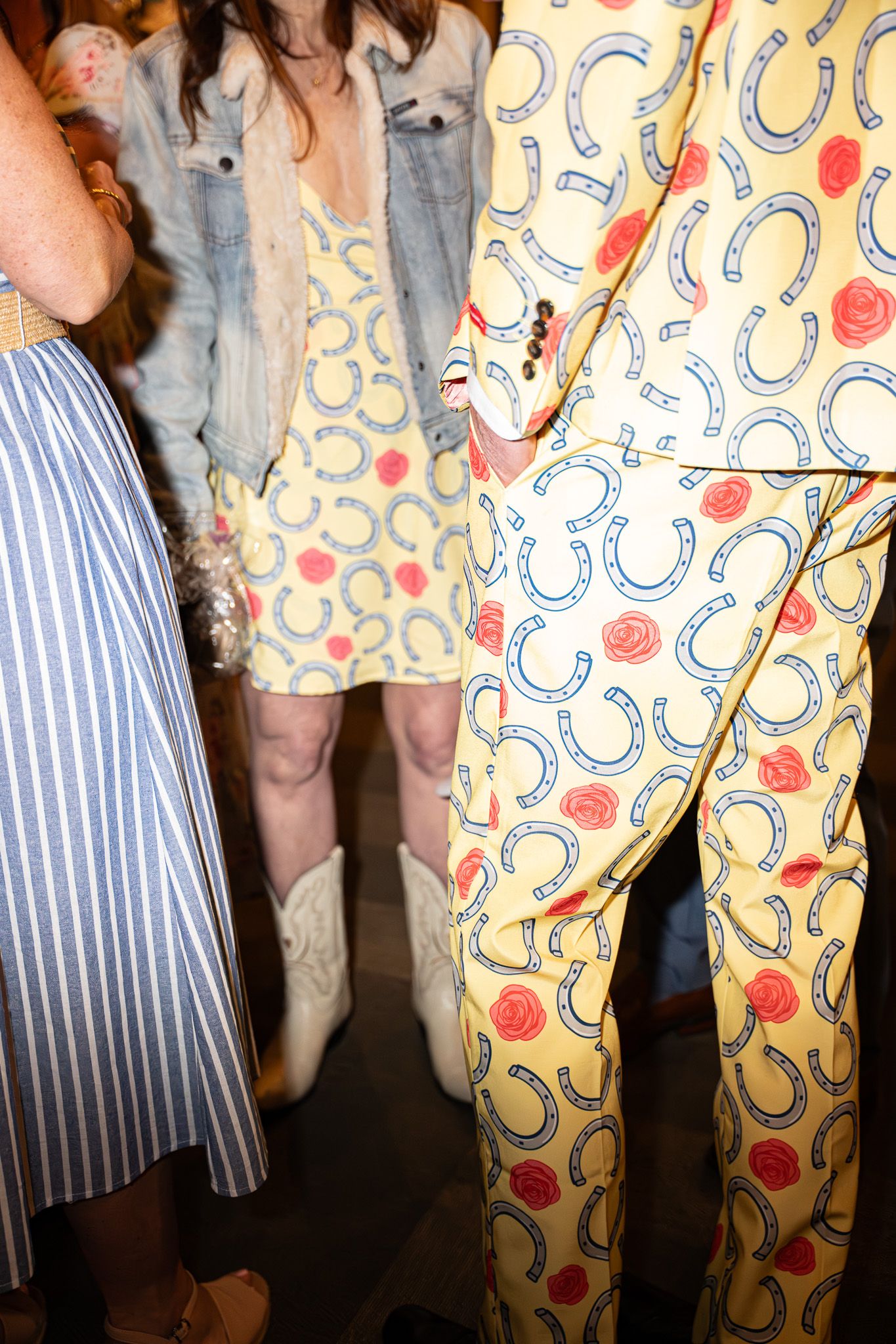Event photography of a direct flash lit group of people wearing wild horseshoe and rose printed suits and dresses for a Kentucky Derby party