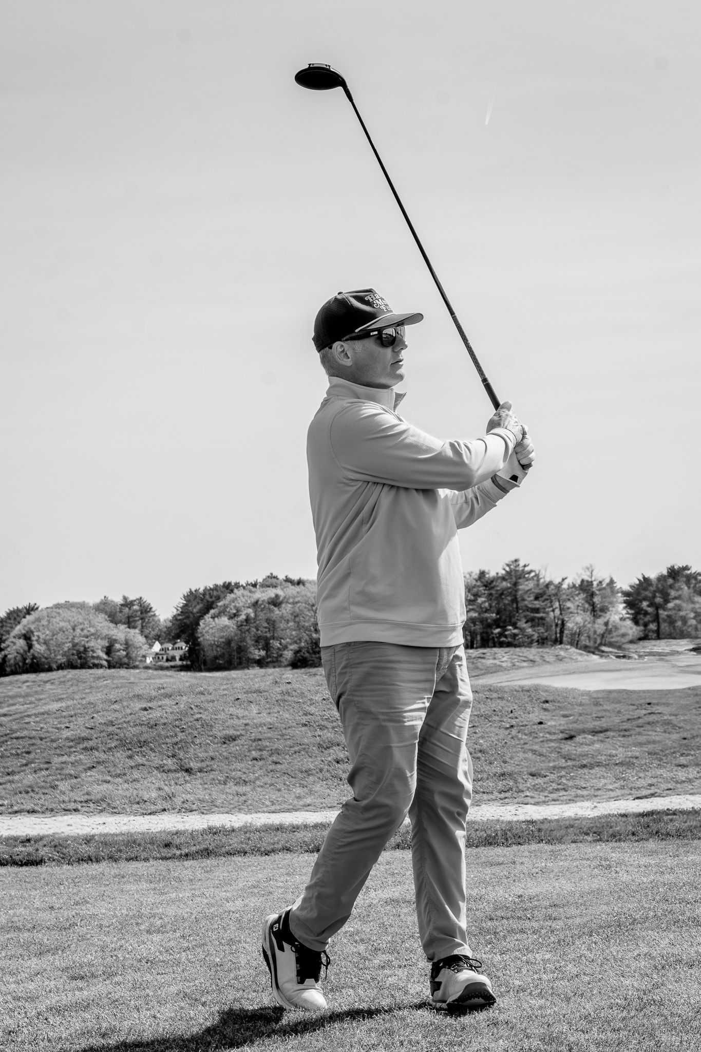 Event photography of a man swinging his golf club during a charity fundraiser golf tournament at Wentworth by the Sea Country Club.