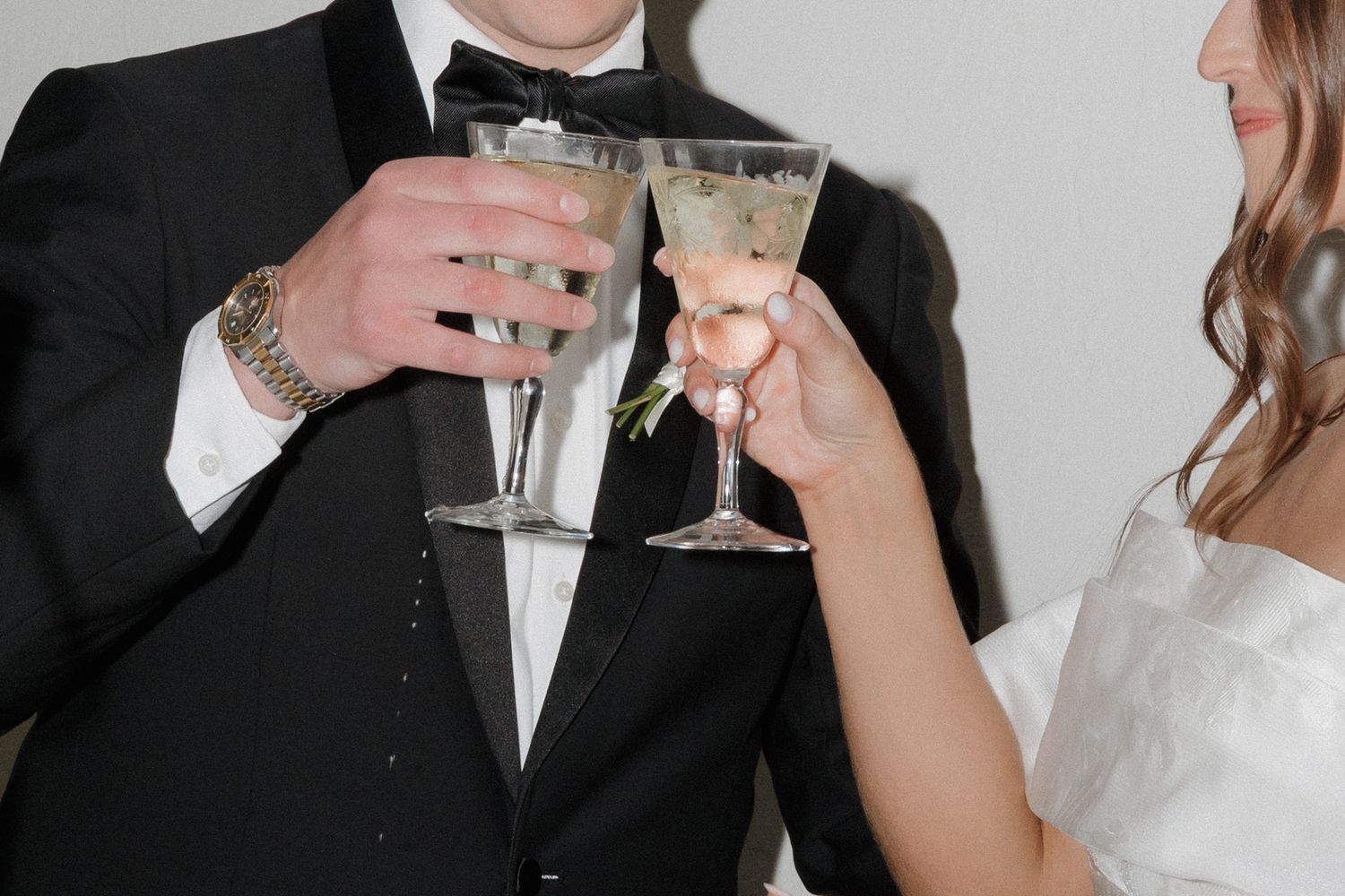 Bride and groom toast their glasses in this flash photo.