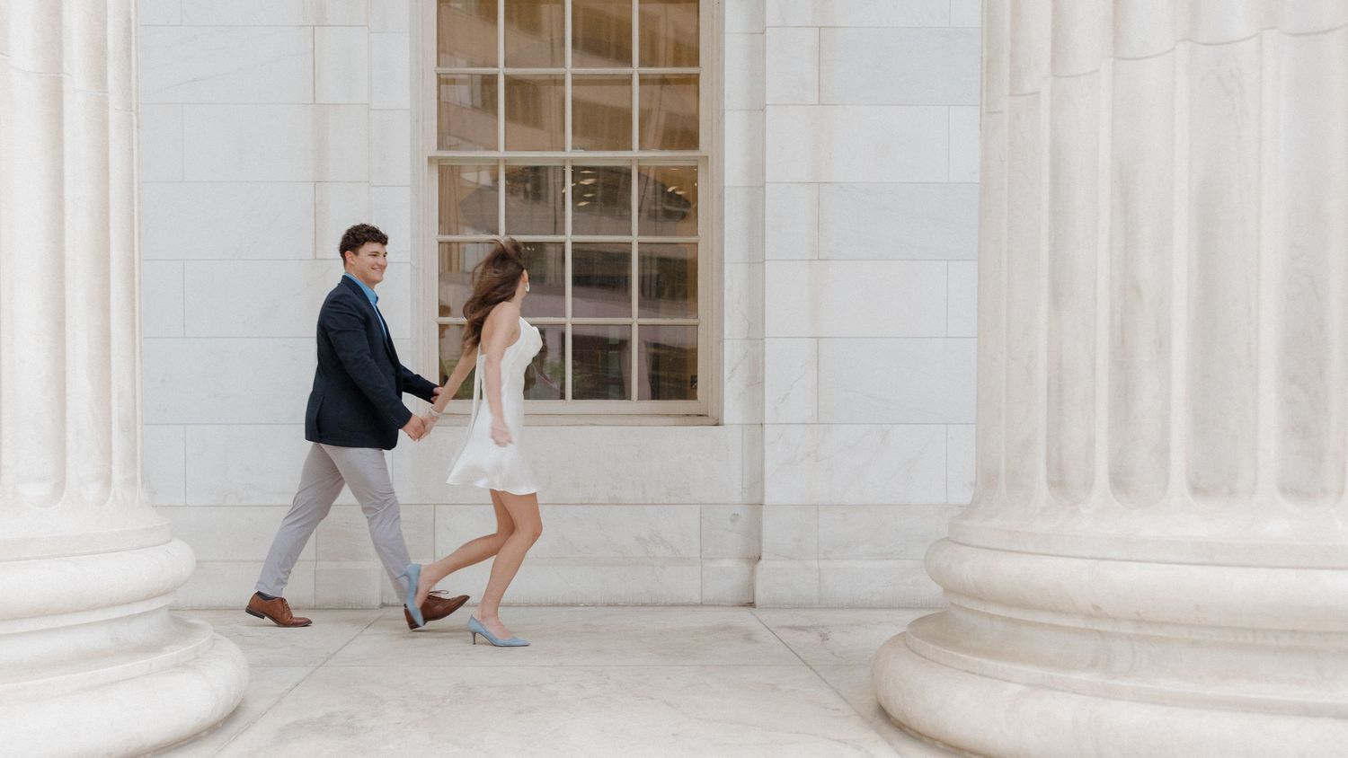 Couple walking together during engagement session at Byron White Courthouse with motion blur, captured by Denver engagement photographer