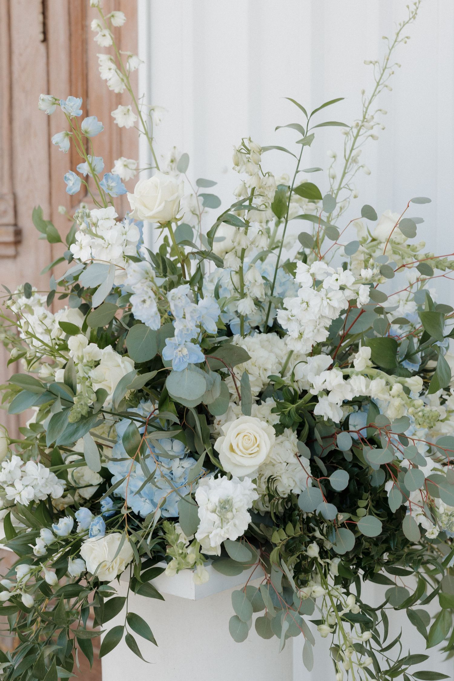 White, blue, and green floral arrangement outside Cold Springs Events venue in Arkansas