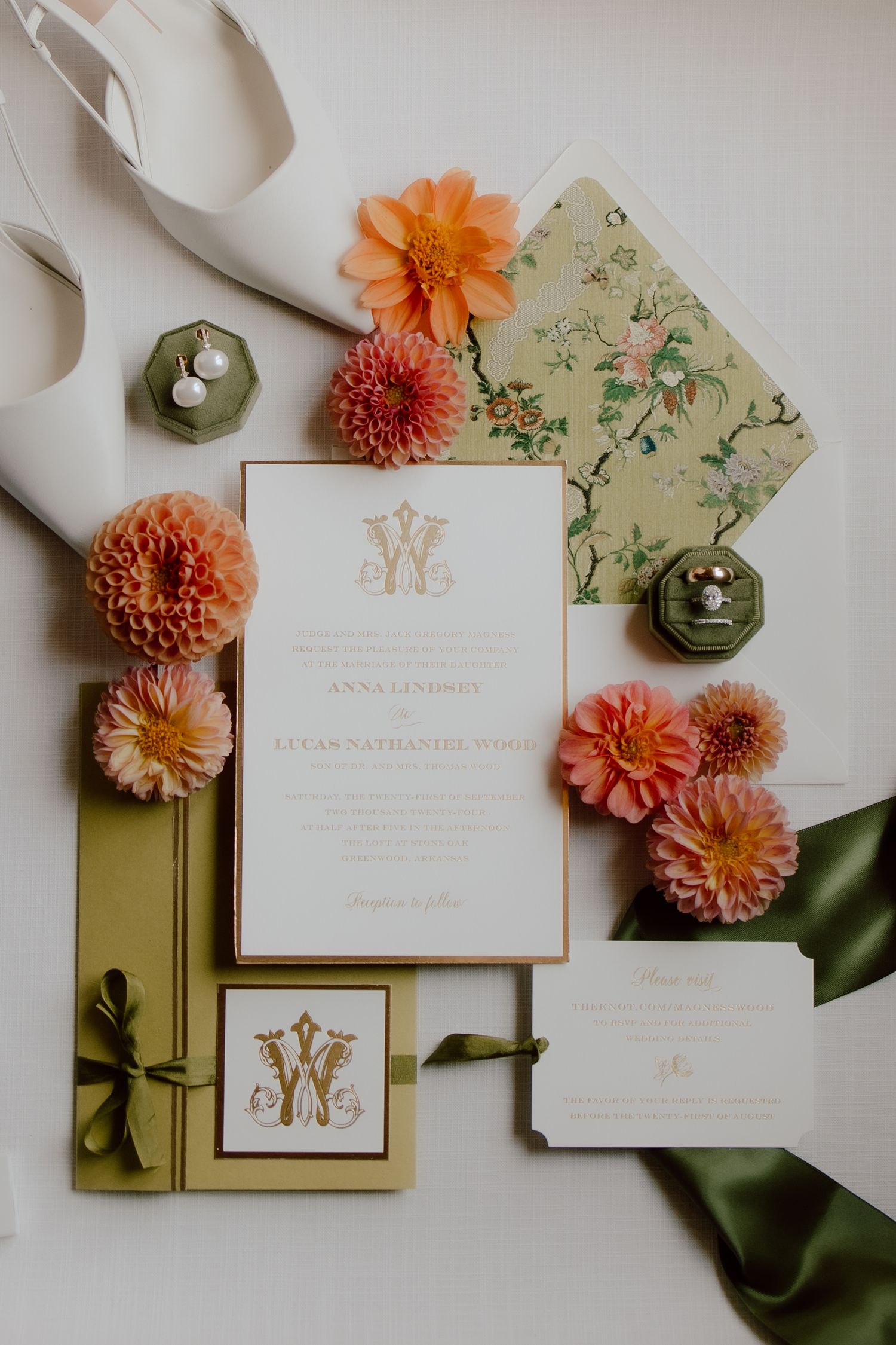 Wedding detail flatlay including invitation to Arkansas wedding, peach and green tones, floral invitation suite, and classic bridal shoes.