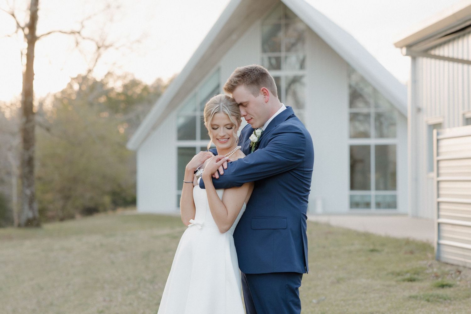 Bride and groom standing by white chapel at Cold Springs Events Arkansas