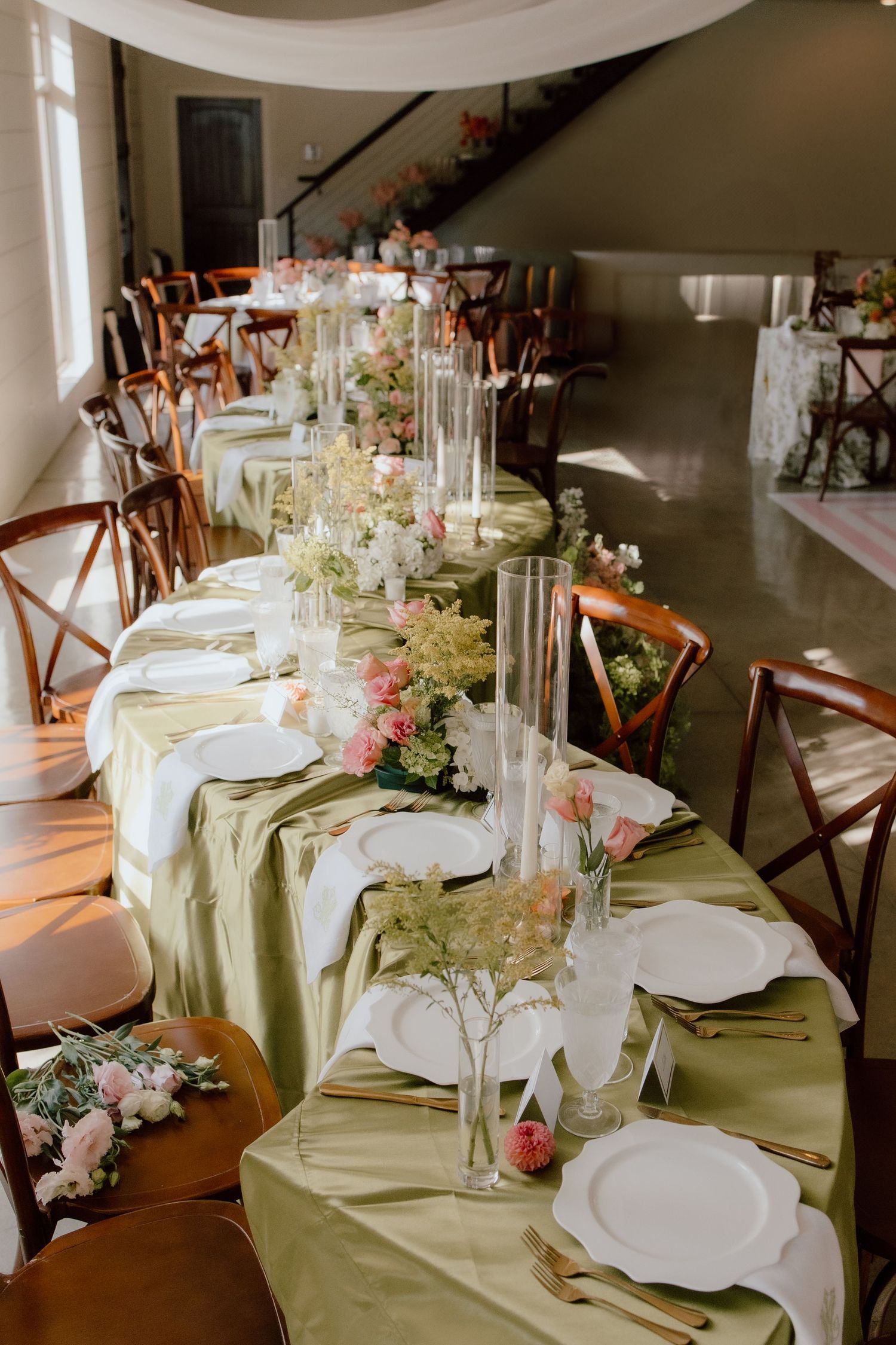 Unique serpentine table scape with a swirl pattern at wedding reception with green table cloth, perfect for 2025 bride inspiration.