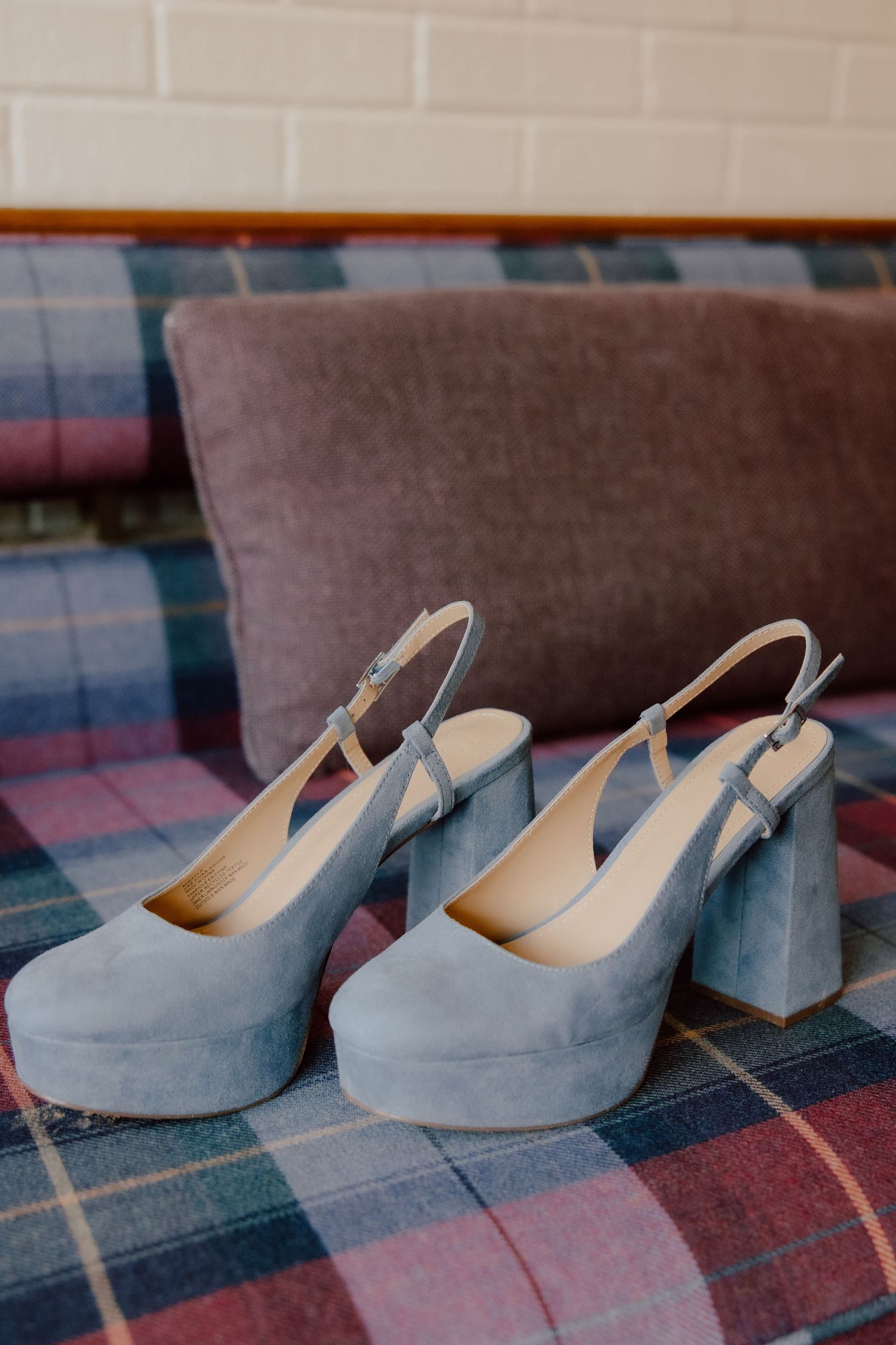 Brides platform blue heels on the blue and purple plaid couch at the Graduate Hotel in Fayetteville, Arkansas.