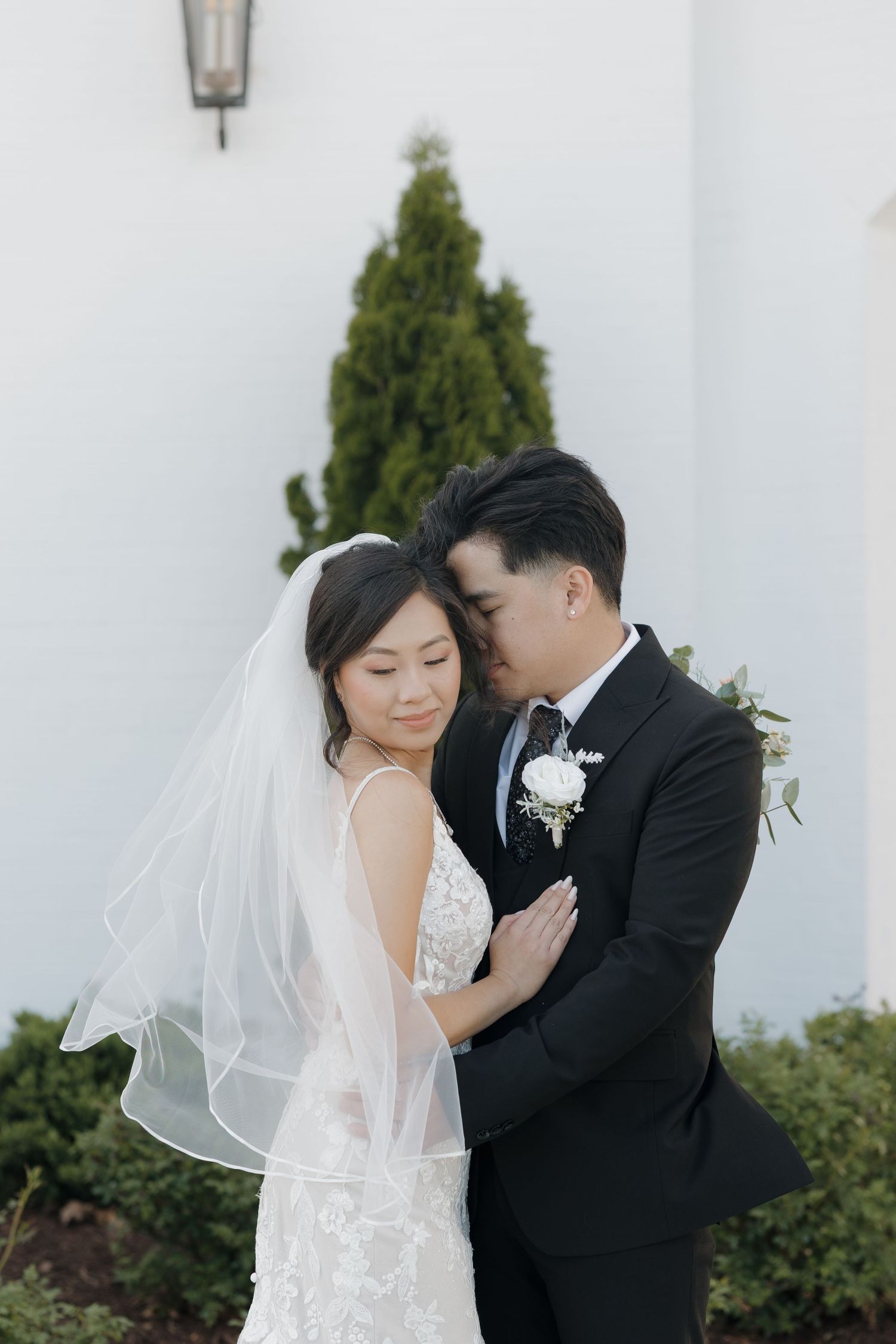 Bride and groom snuggled closely together amidst the backdrop of The Grand.