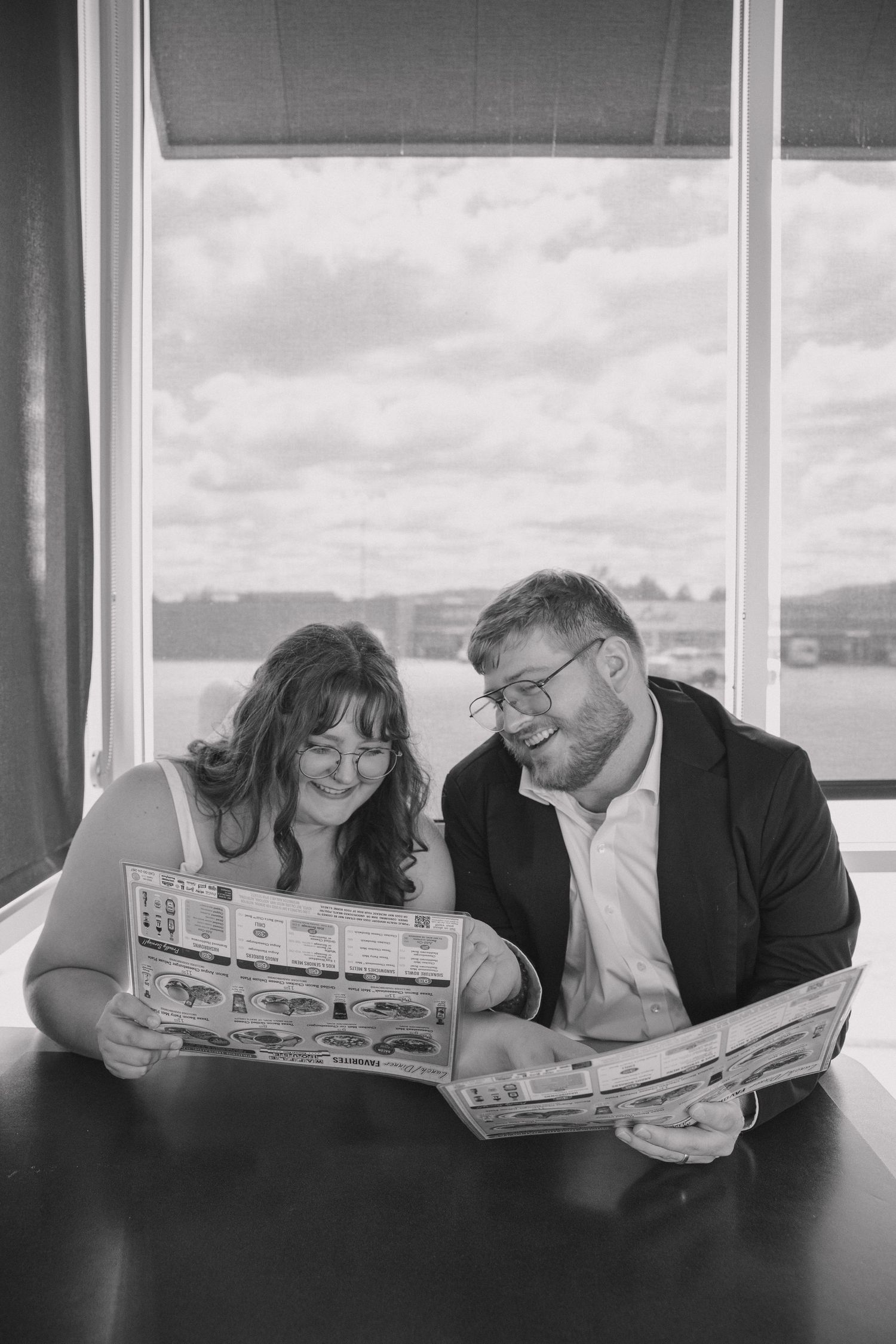 Wedding couple in a candid moment inside of Waffle House viewing the menu and laughing joyfully after just eloping.