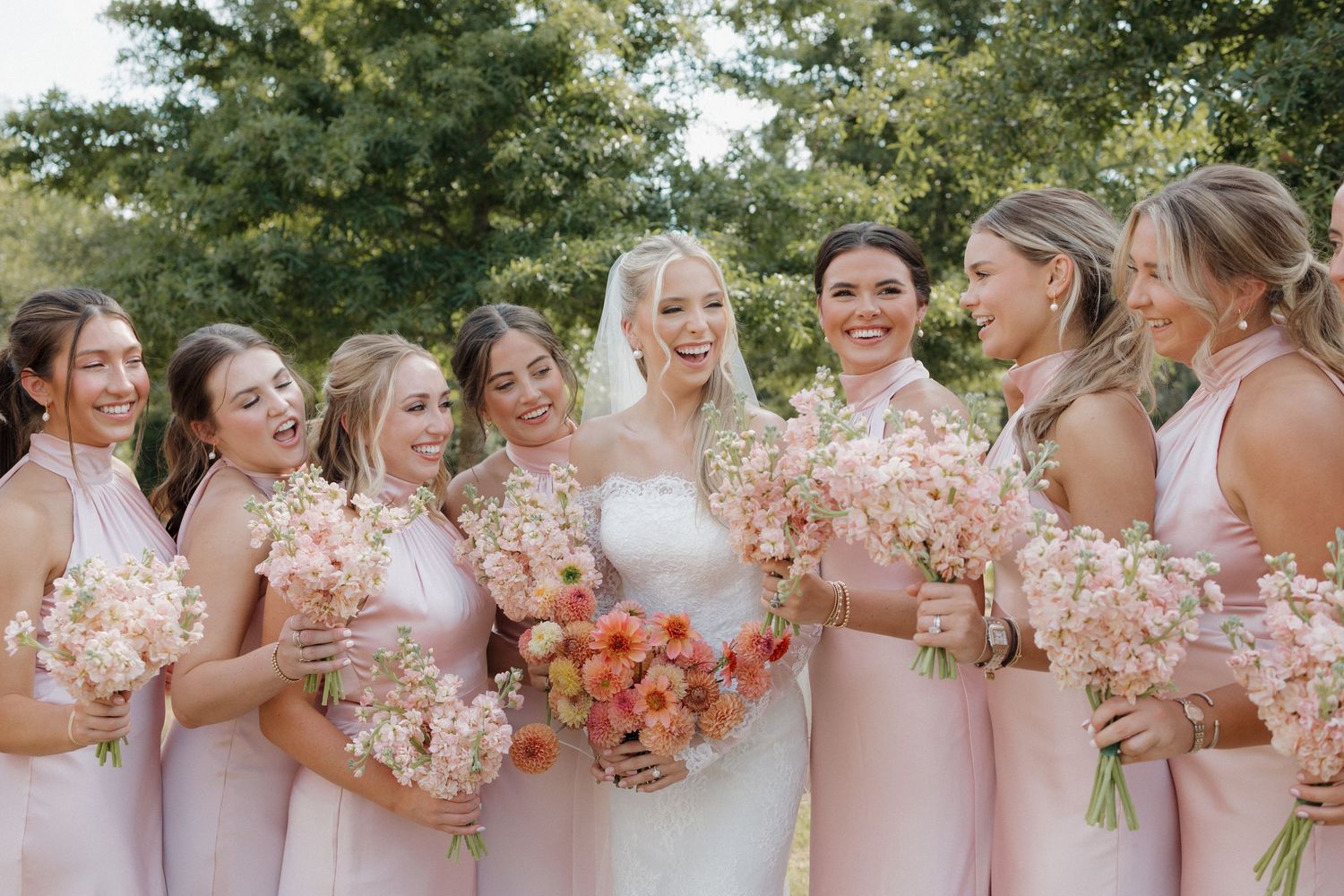 Bride surrounding by her bridesmaids all happy and joyful.