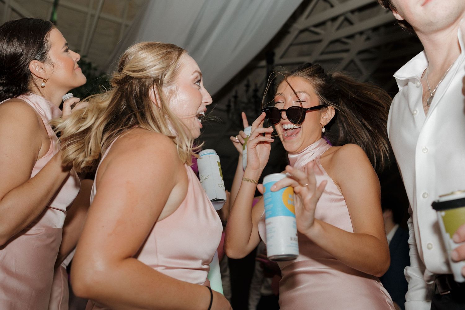 Wedding dance floor moment with bridesmaids partying wearing sunglasses.