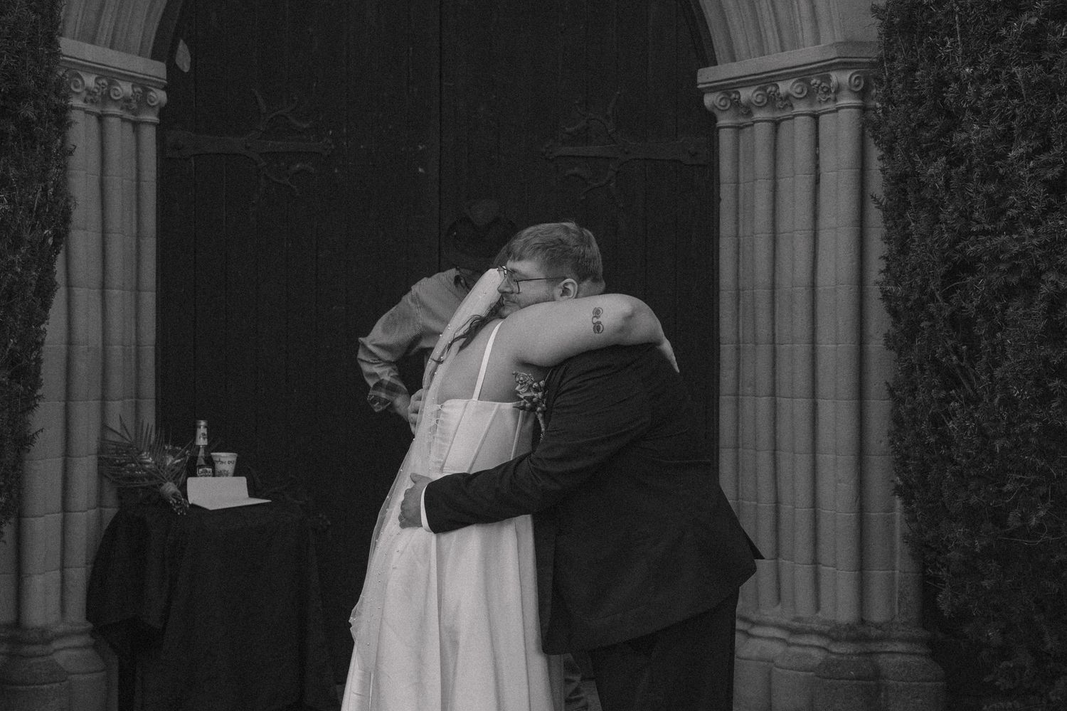 Documentary style photography capturing the bride and groom in a candid moment hugging during elopement wedding ceremony in Arkansas.
