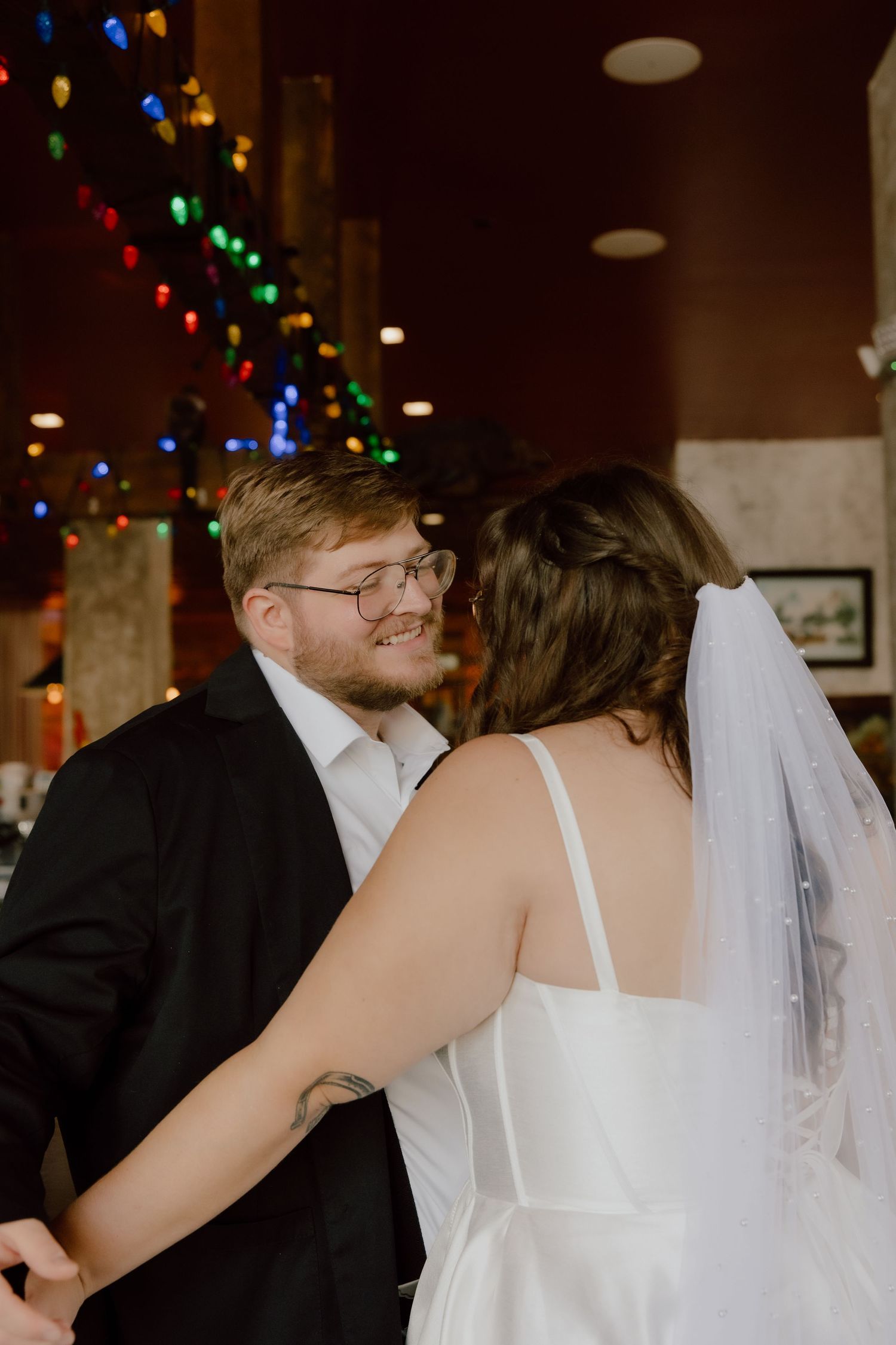 Bride and groom in a candid photo in the bar area of the Graduate Hotel for a moody romantic portrait.