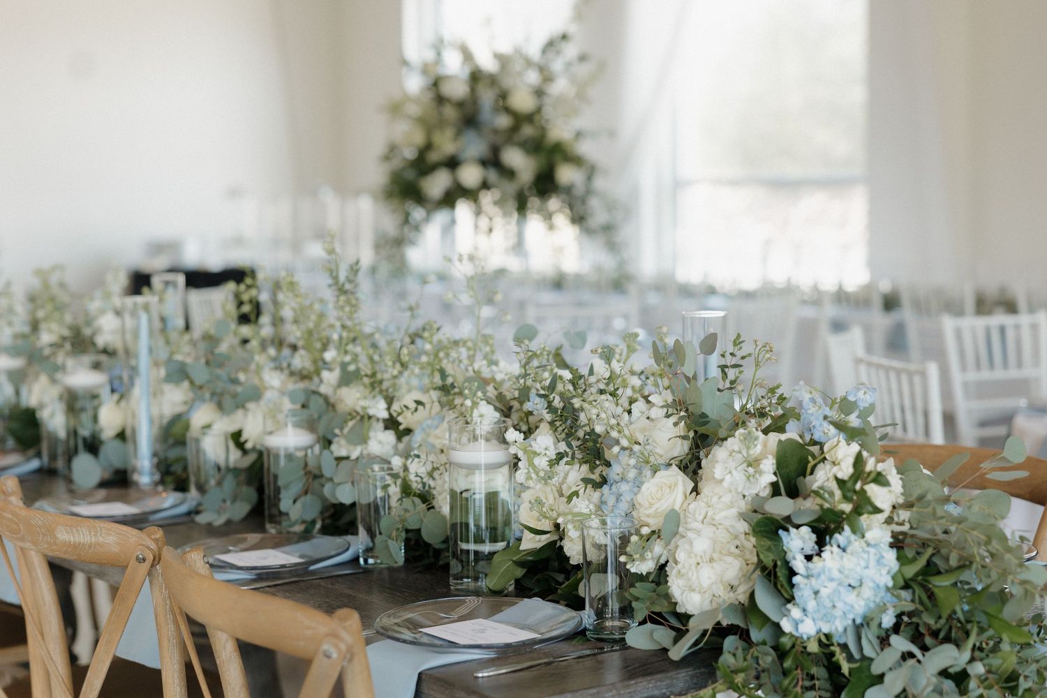 Reception tables blue white linens and greenery at Cold Springs Events