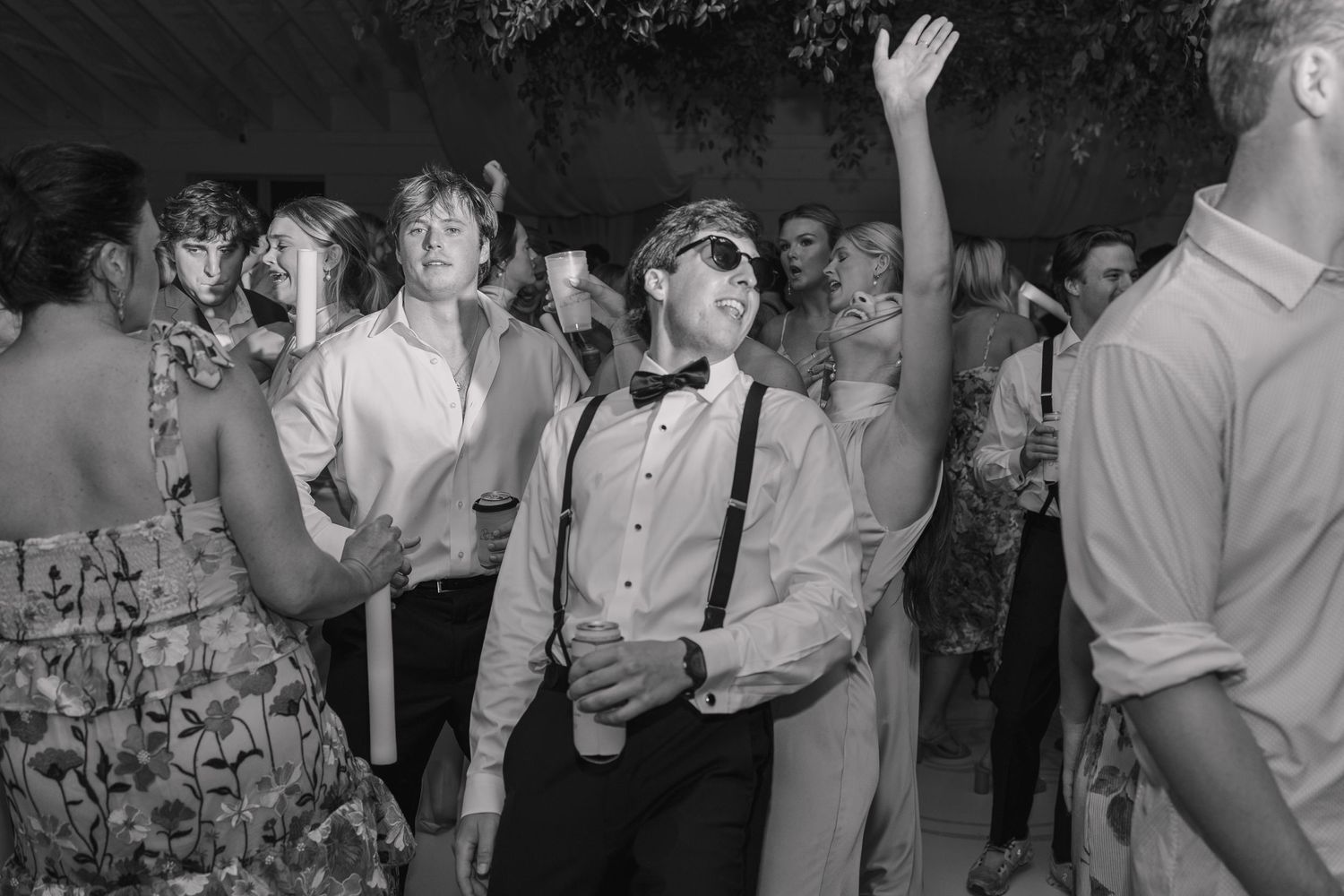 Dance floor black and white photo with flash of guests celebrating.