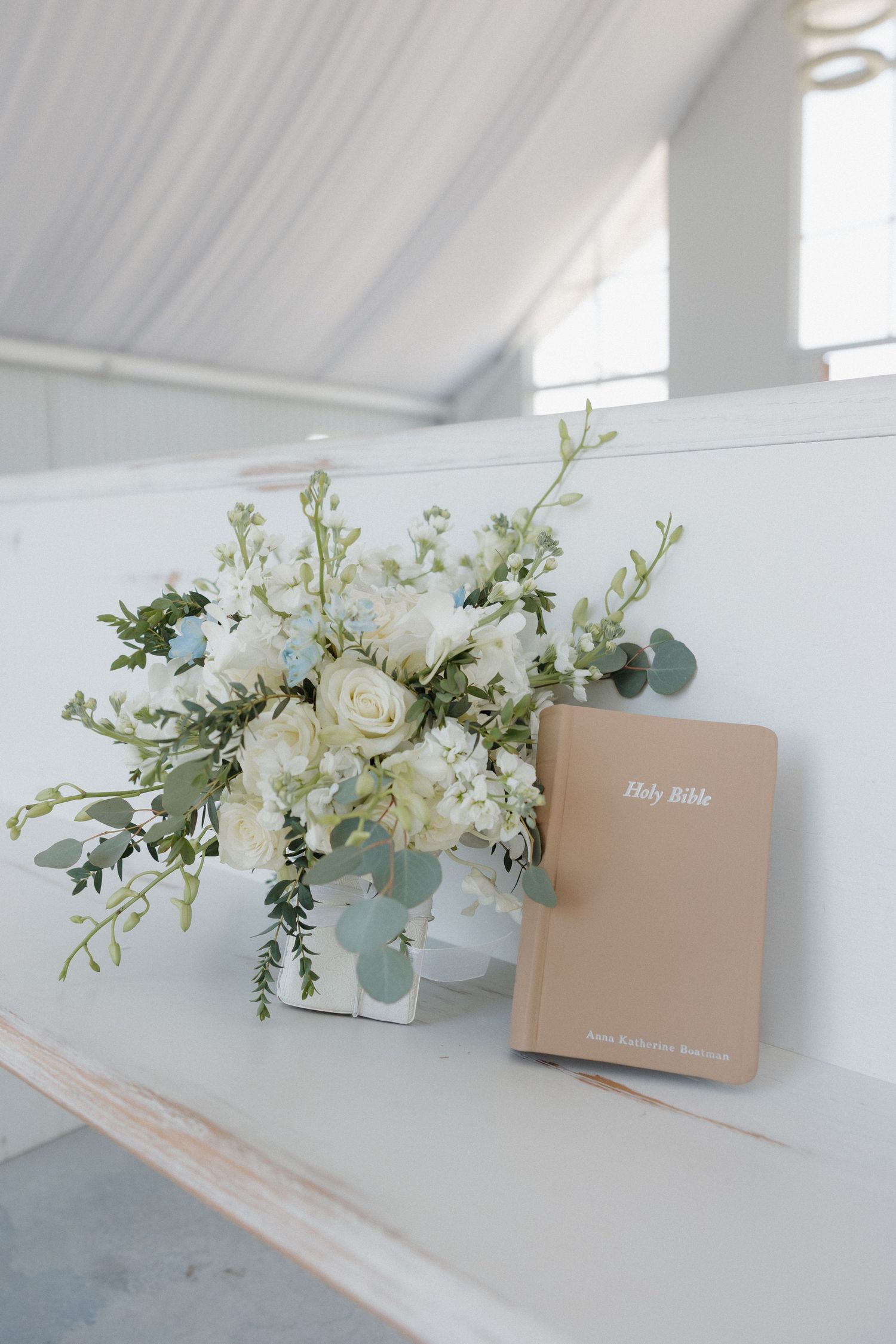 White and green bridal bouquet next to custom bible at Cold Springs Events in Arkansas
