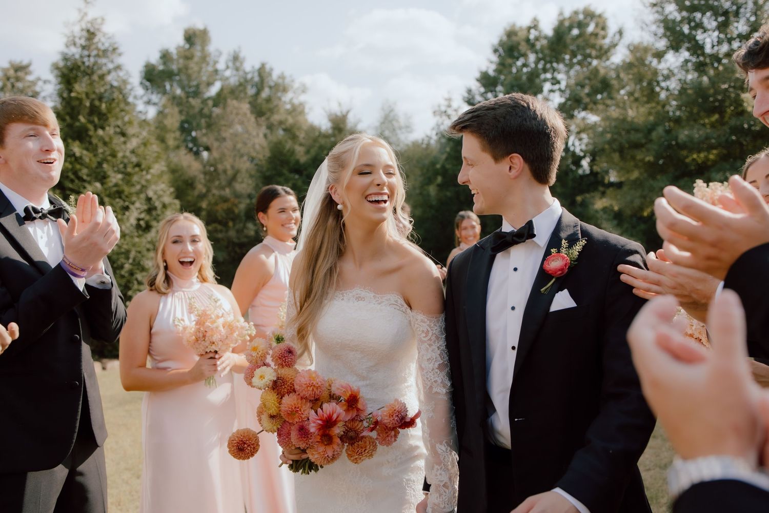 Bride and groom in a candid moment, documentary style wedding photographer captured this photo of couple with wedding party in Arkansas.