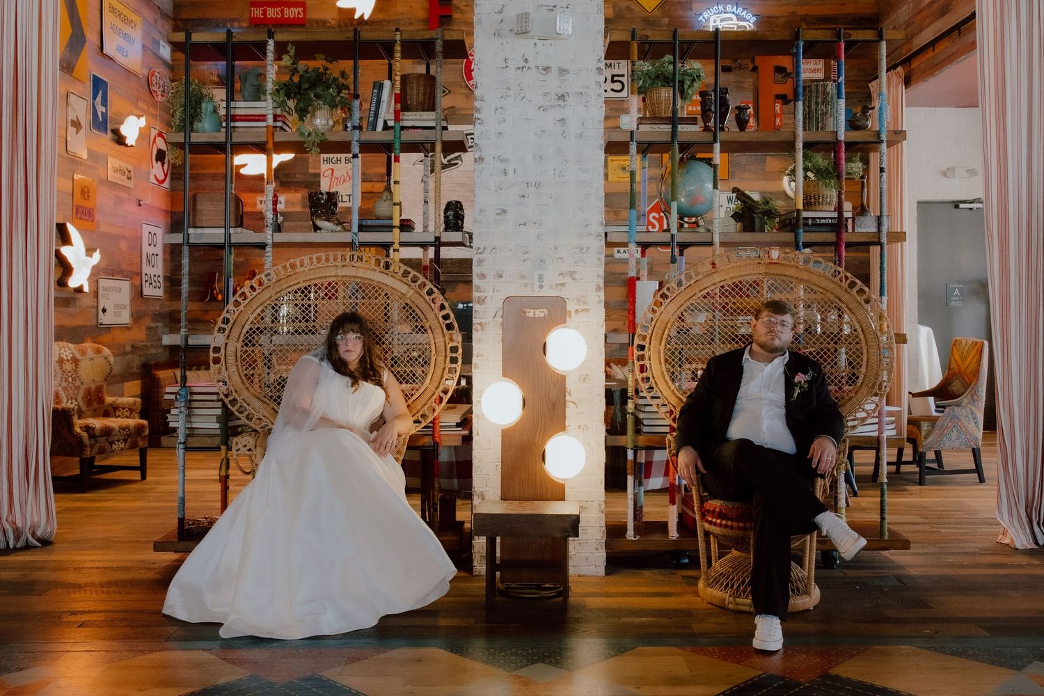 Bride and groom pose for editorial moment in the maximalist unique Hotel, The Graduate both seated in peacock chairs.