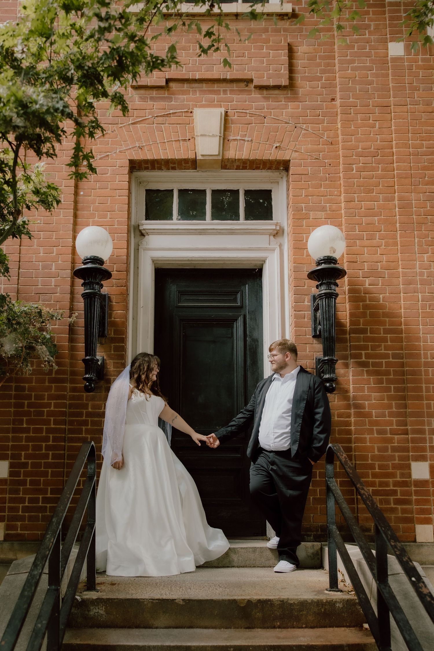 Fayetteville, Arkansas downtown square wedding portraits of bride and groom in front of historic brick building.