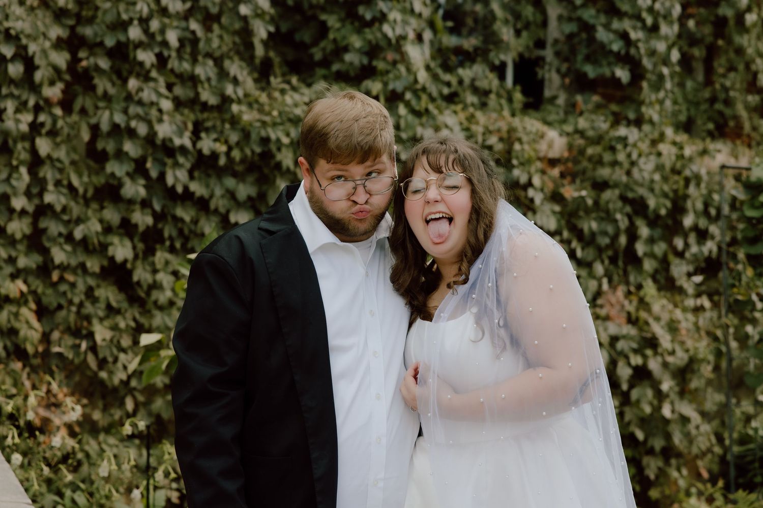 Bride and groom making silly faces at the camera as they are comfortable with their wedding photographer and having the best time.