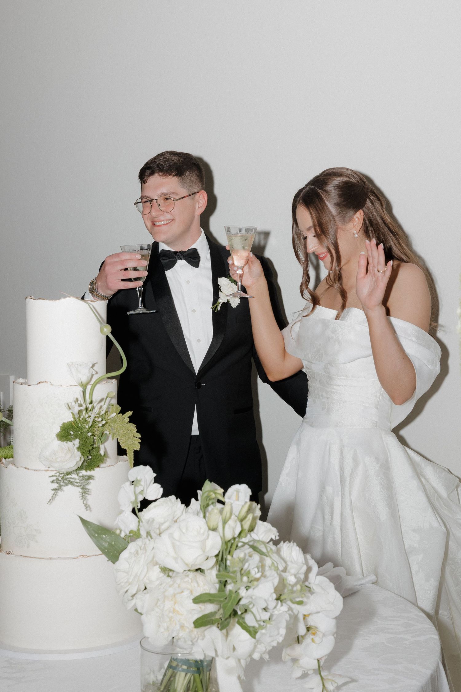 Flash nightime photo of bride and groom cutting their cake during reception.
