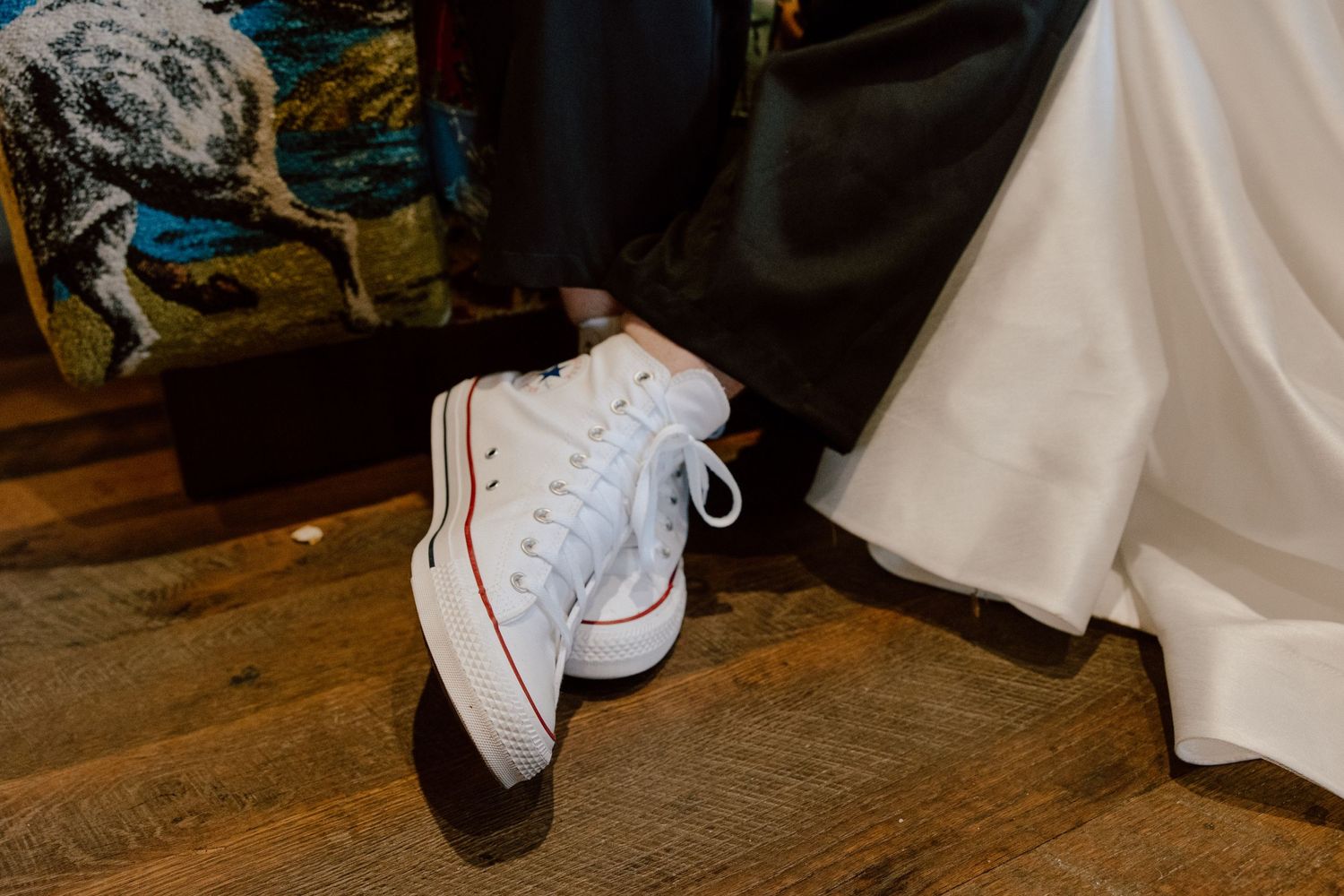 Groom wearing white converse shoes on his wedding day.