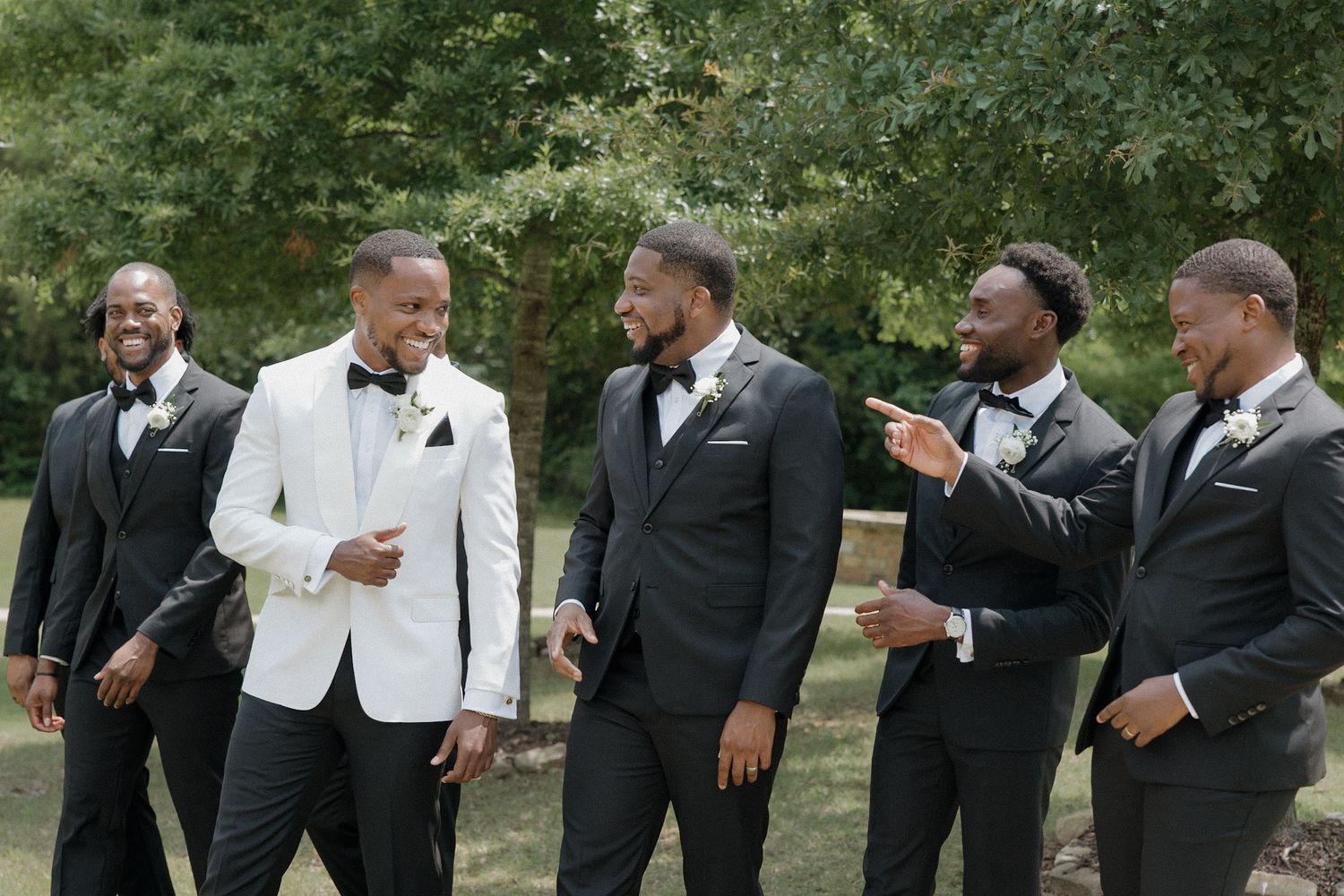 Groom is outside with his groomsmen celebrating before their wedding day.