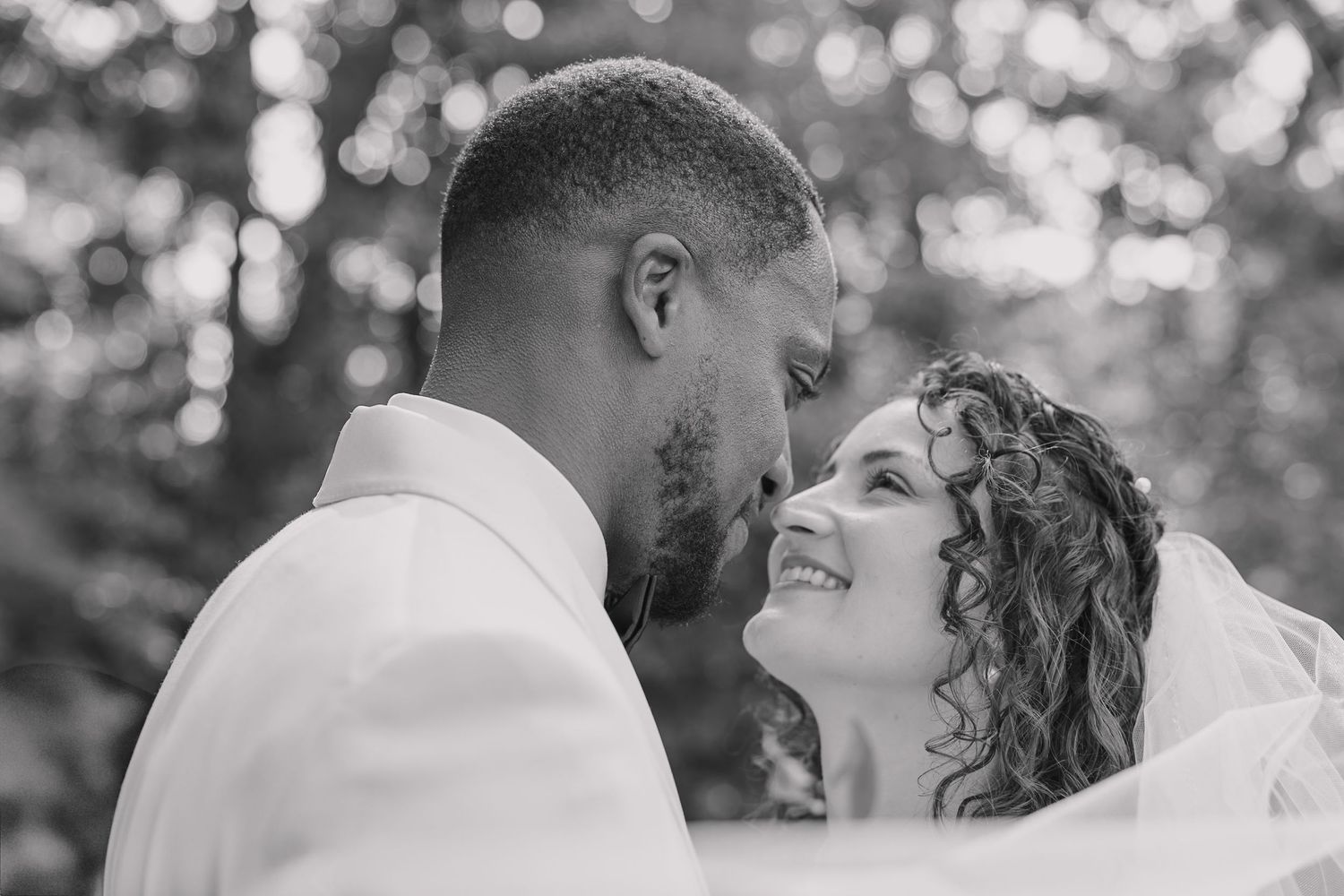 Sweeping veil phoot with bride and groom looking into each others eyes lovingly.