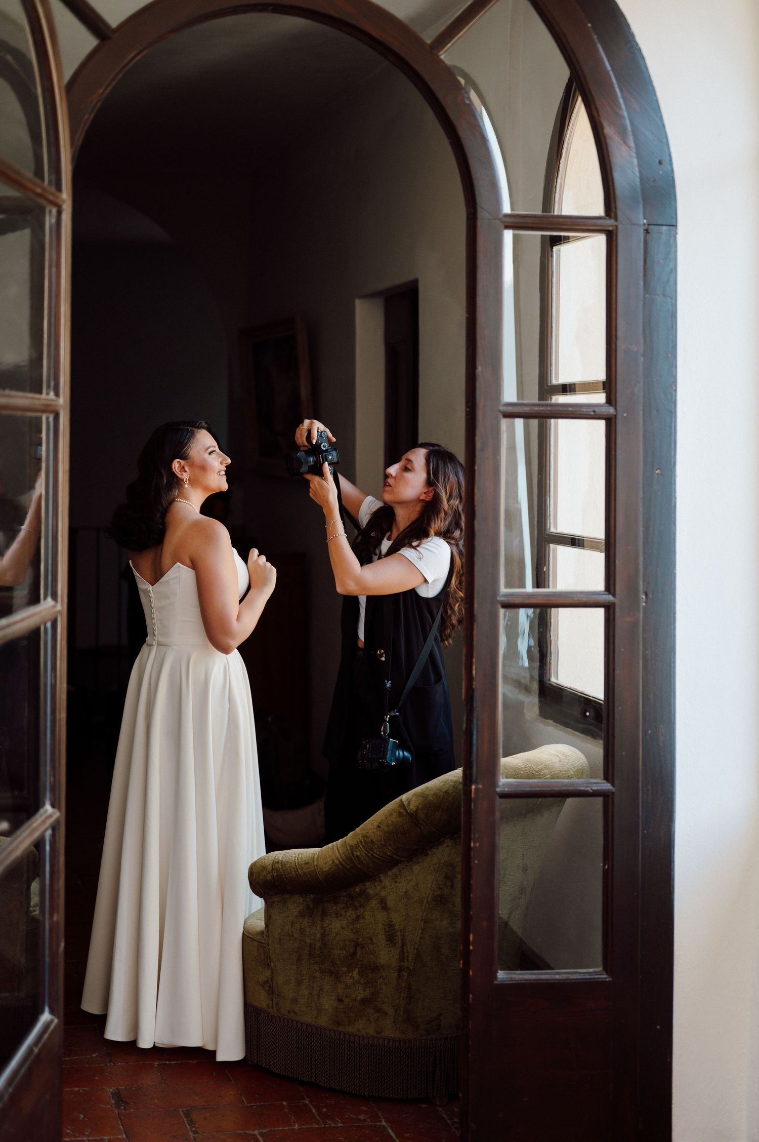 ritratto fotografico con sposa e fotografa Laura Doninelli al lavoro mentre ritrae la sua cliente sposa in location a castello Oldofredi