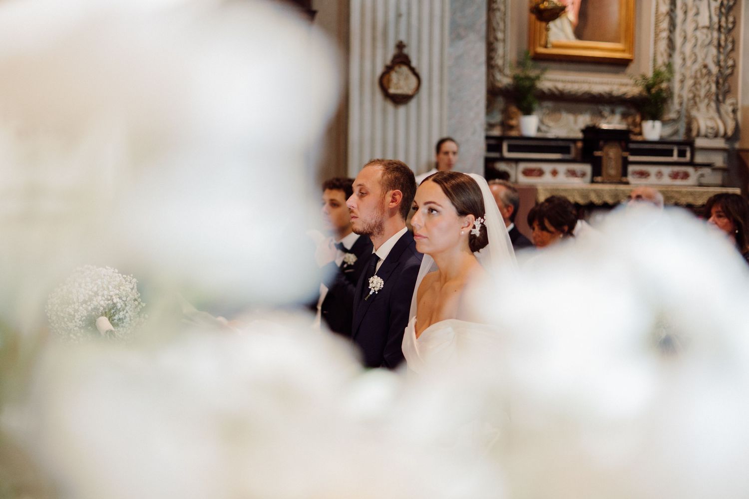 ritratto fotografico degli sposi durante la messa in chiesa a Iseo