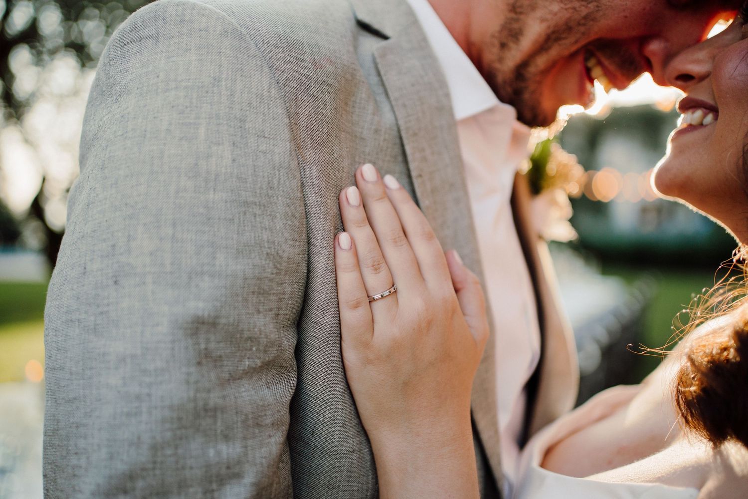 Close-up romantic moment between a couple in formal attire with soft natural lighting.