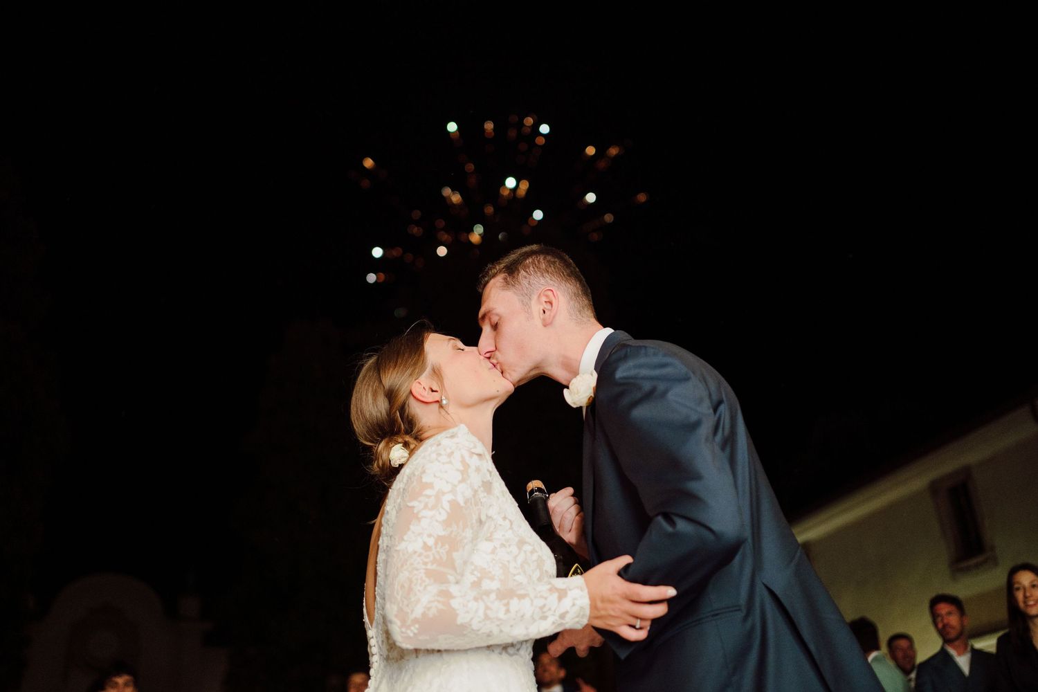 Romantic evening dance scene at an outdoor wedding reception with string lights.
