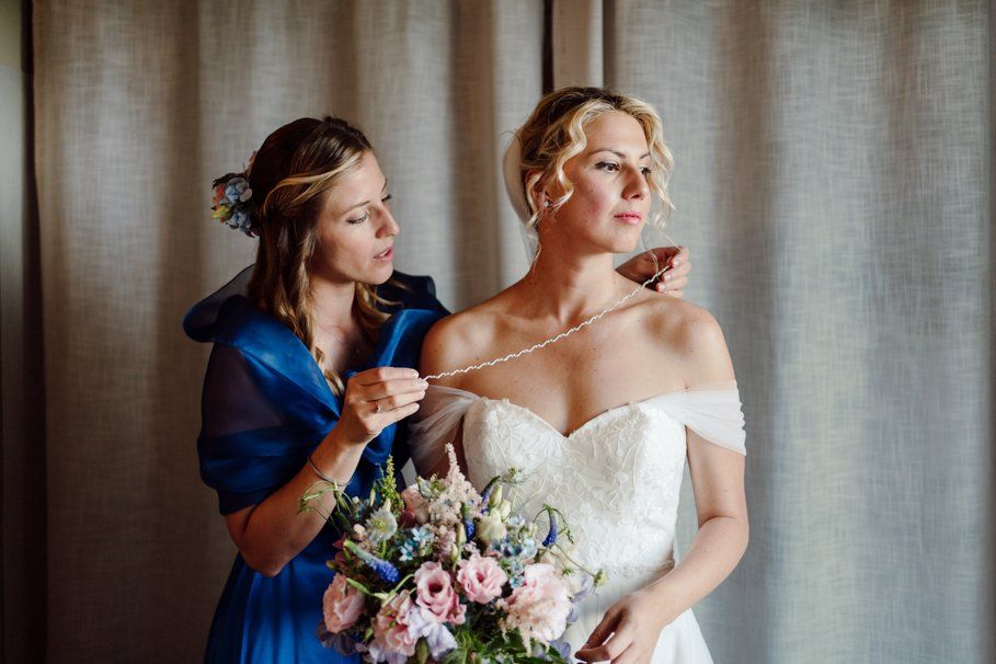 dettaglio preparativi della sposa in location a Tenuta Frizzoni mentre indossa la sua collana